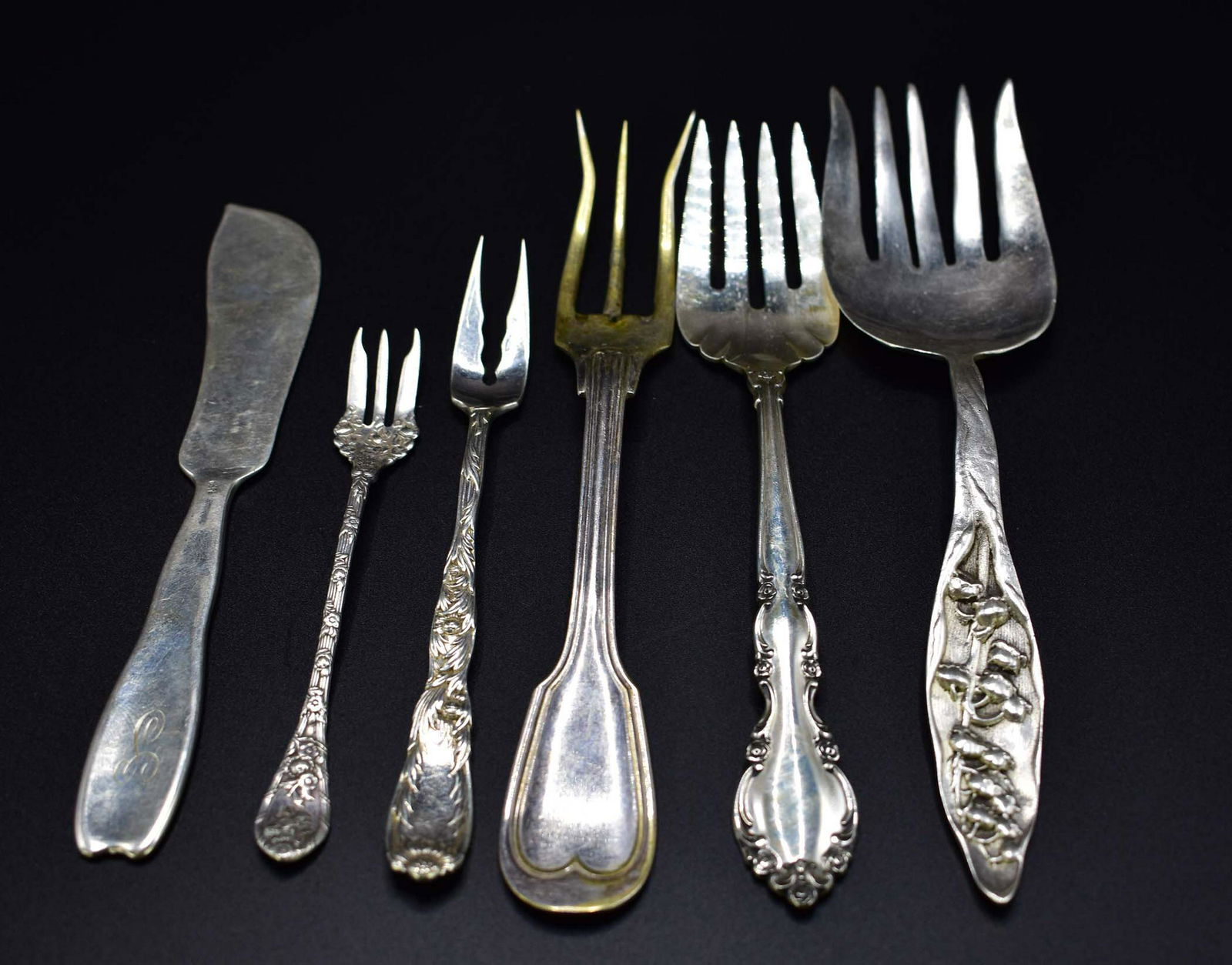 SIX STERLING SILVER SERVING PIECES: English and American. Late 19th/20th Century. Including: a Tiffany & Co. oyster fork, an Art Nouveau fish fork and slice. 10.7 troy oz. Length of largest 9 in. (Cond: good)