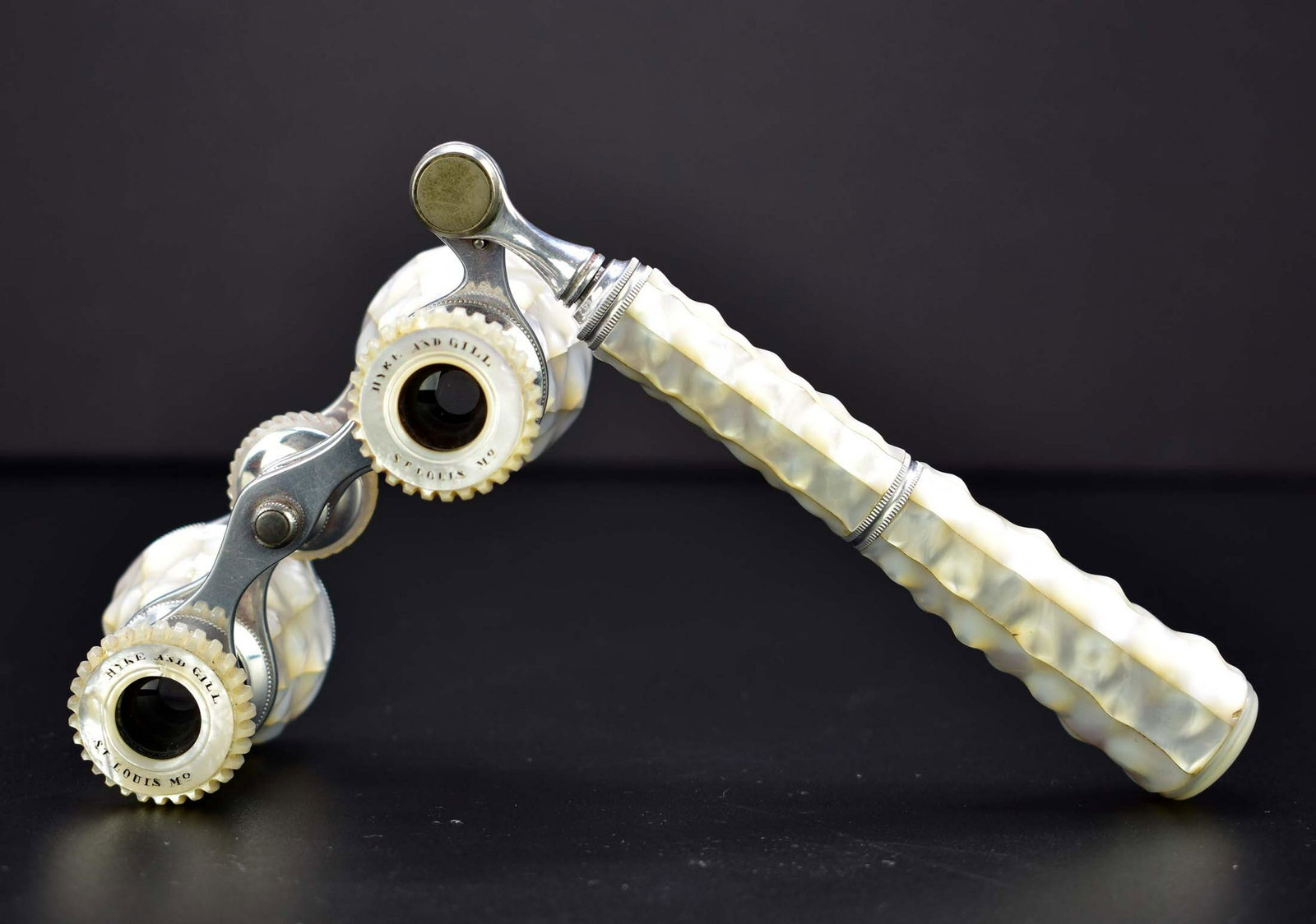 PAIR OF AMERICAN MOTHER OF PEARL OPERA GLASSES: Late 19th Century. Marked HYDE & GILL, ST LOUIS, MO., with panels of Mother of Pearl, with an extendable arm. (Cond: good)