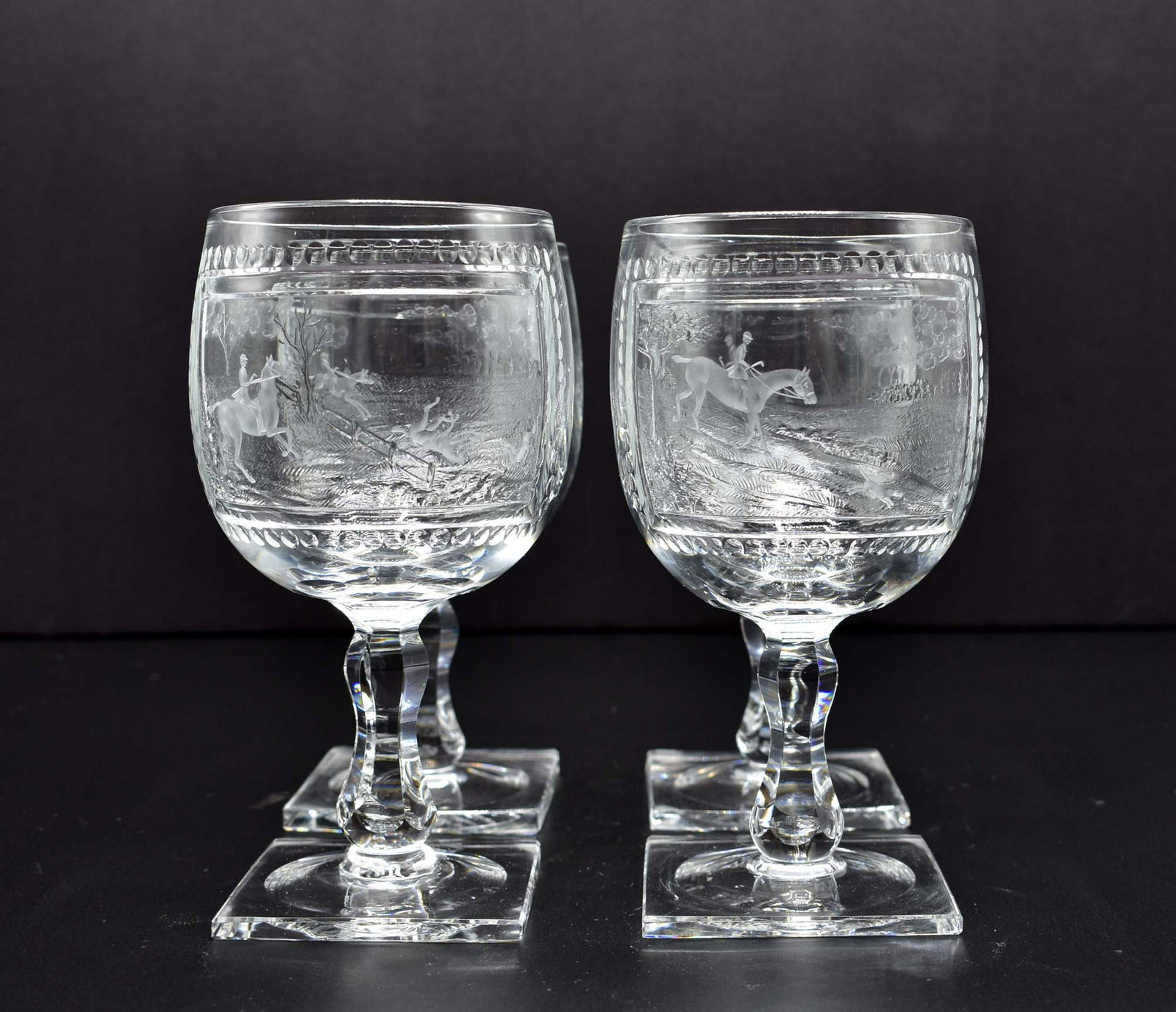 SET OF FOUR THOMAS WEBB EQUESTRIAN GLASS GOBLETS: English. 1st Half 20th Century. Each cup shaped bowl engraved with panels depicting a hunt scene with hounds, with shaped stems and a squared foot. Height 6.5 in. Diameter 3.25 in. (Cond: good) Proven