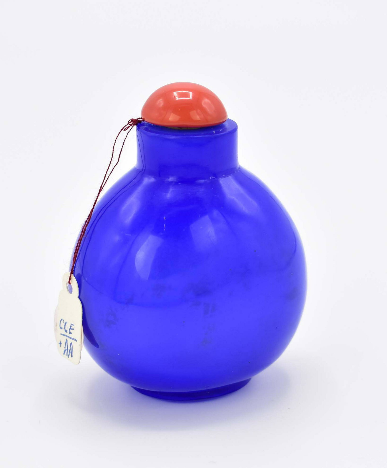 CHINESE PEKING BLUE GLASS SNUFF BOTTLE: The ovoid vessel with a carnelian stopper and spoon. Height 2.75 in. (Cond: good)