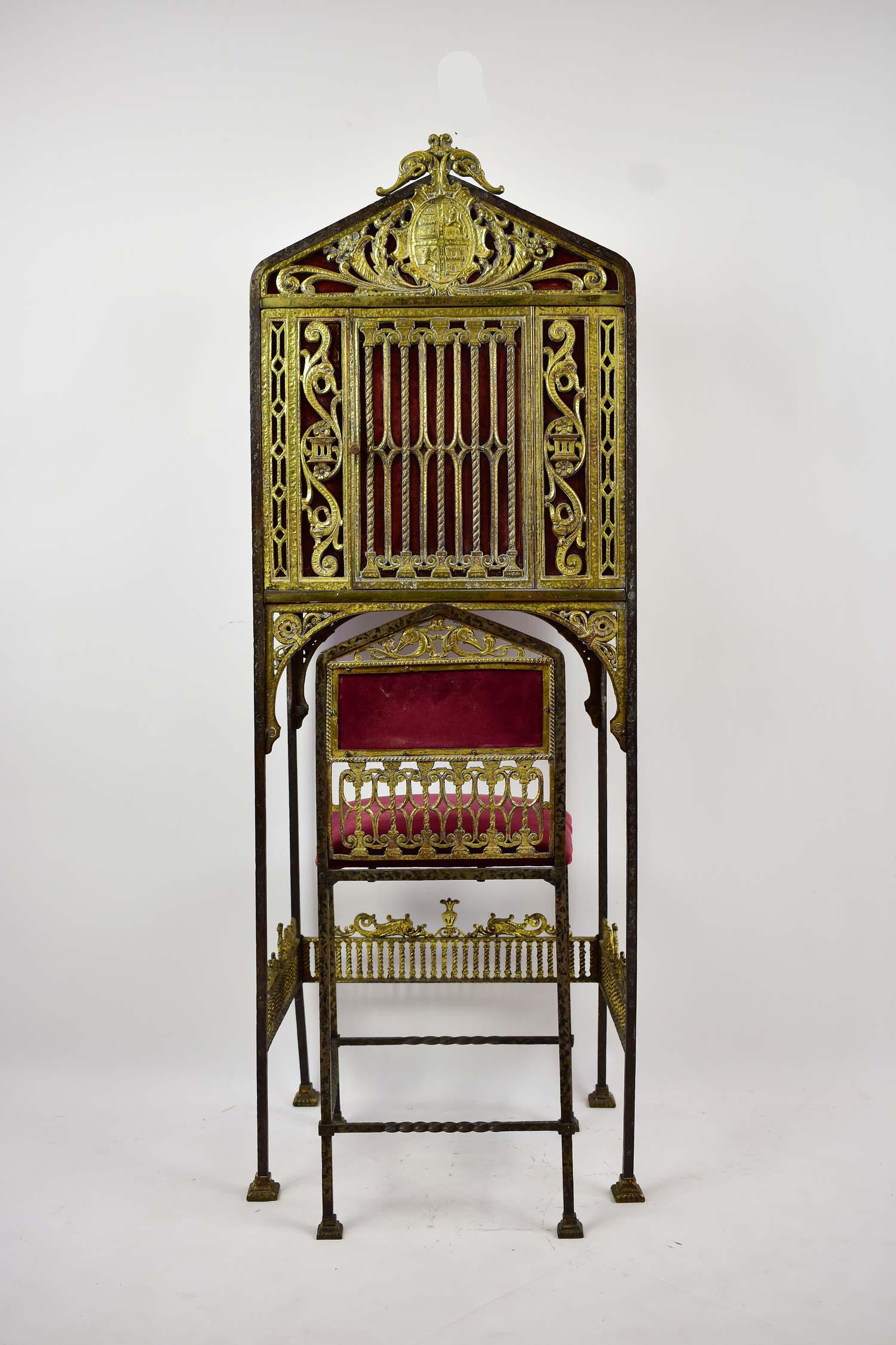 OSCAR BACH (German/American. 1884-1957): GILT WROUGHT IRON JEWELRY CABINET & SLIPPER CHAIR Circa 1920. In a Renaissance style. The square cabinet with a triangular pediment cabinet centering a heraldic device, the case with a door, on straig