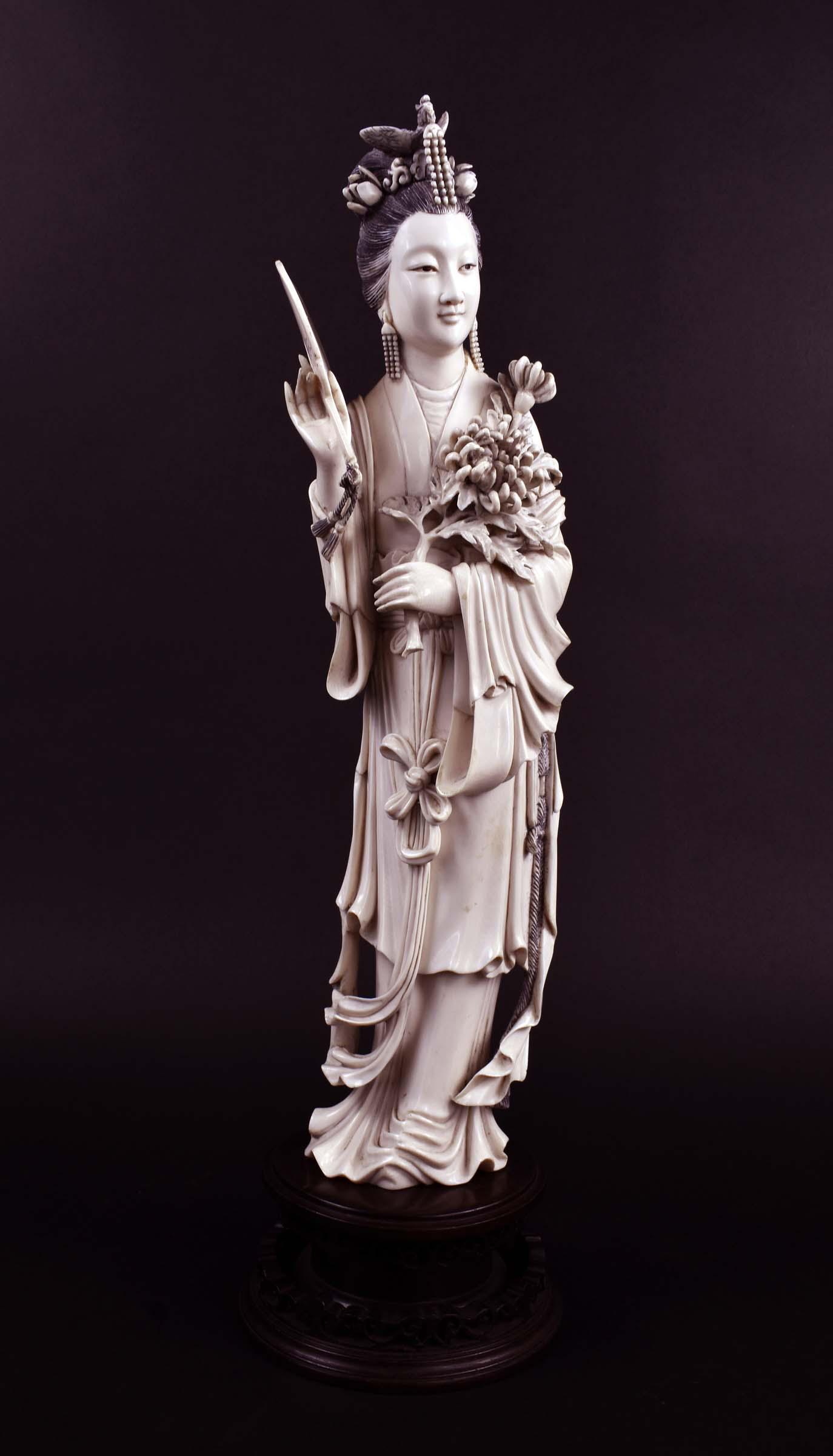 FINE CHINESE CARVED FIGURE OF A MERIN: The elegant lady with elaborate coifed hair, wearing layered robes, holding a rose stem and a fan. Height 15 in., overall 18 in. (Cond: good)