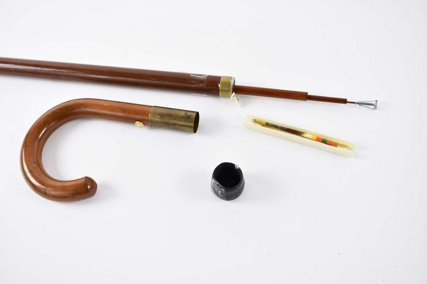 RARE GUCCI METAMORPHIC FISHING ROD CANE: Last Quarter 20th Century. Signed Gucci, Italy on a gilt tag. Both the crook handle and ferule opening to a sectional fishing rod. Length 37 in. (Cond: good)