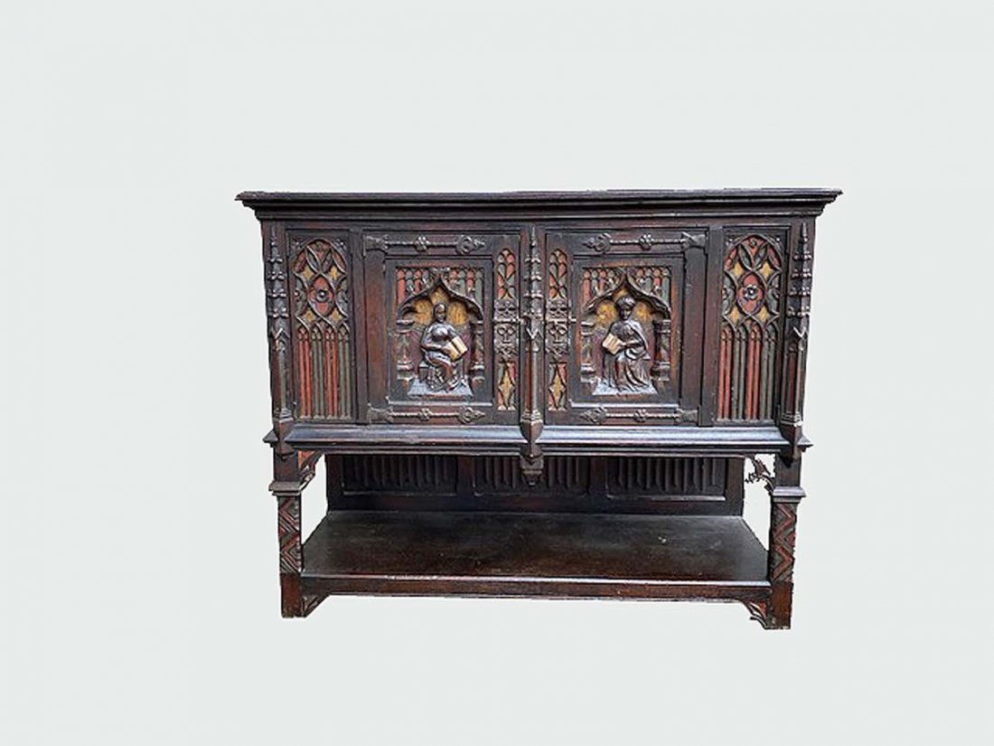 CONTINENTAL MEDIEVAL STYLE PART PAINTED OAK CABINET: Now adapted. Rectangular, with two hinged doors carved in high relief with figural scenes, on straight legs carved with tracery. Height 42.5 in. Width 54 in. Depth 21. (Cond: adapted to accommodate el