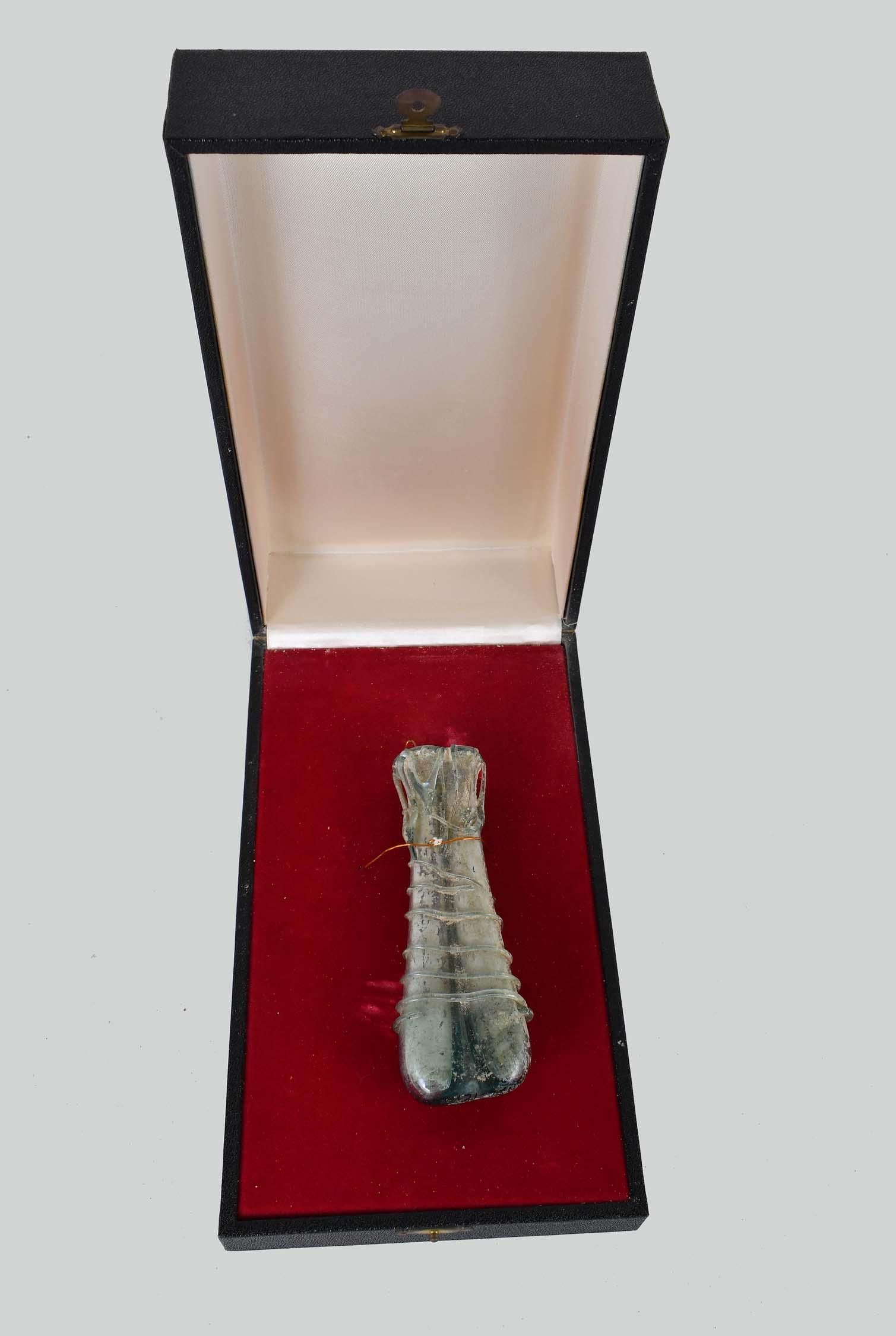 FINE ROMAN IMPERIAL FREE-BLOWN DOUBLE GLASS VILE: 2nd/3rd Century A.D. Inscribed JM 131-75. The translucent aqua-hued glass vial conjoined at the center, wider at the base, and tapering towards the neck, the body partially wrapped with applied linear