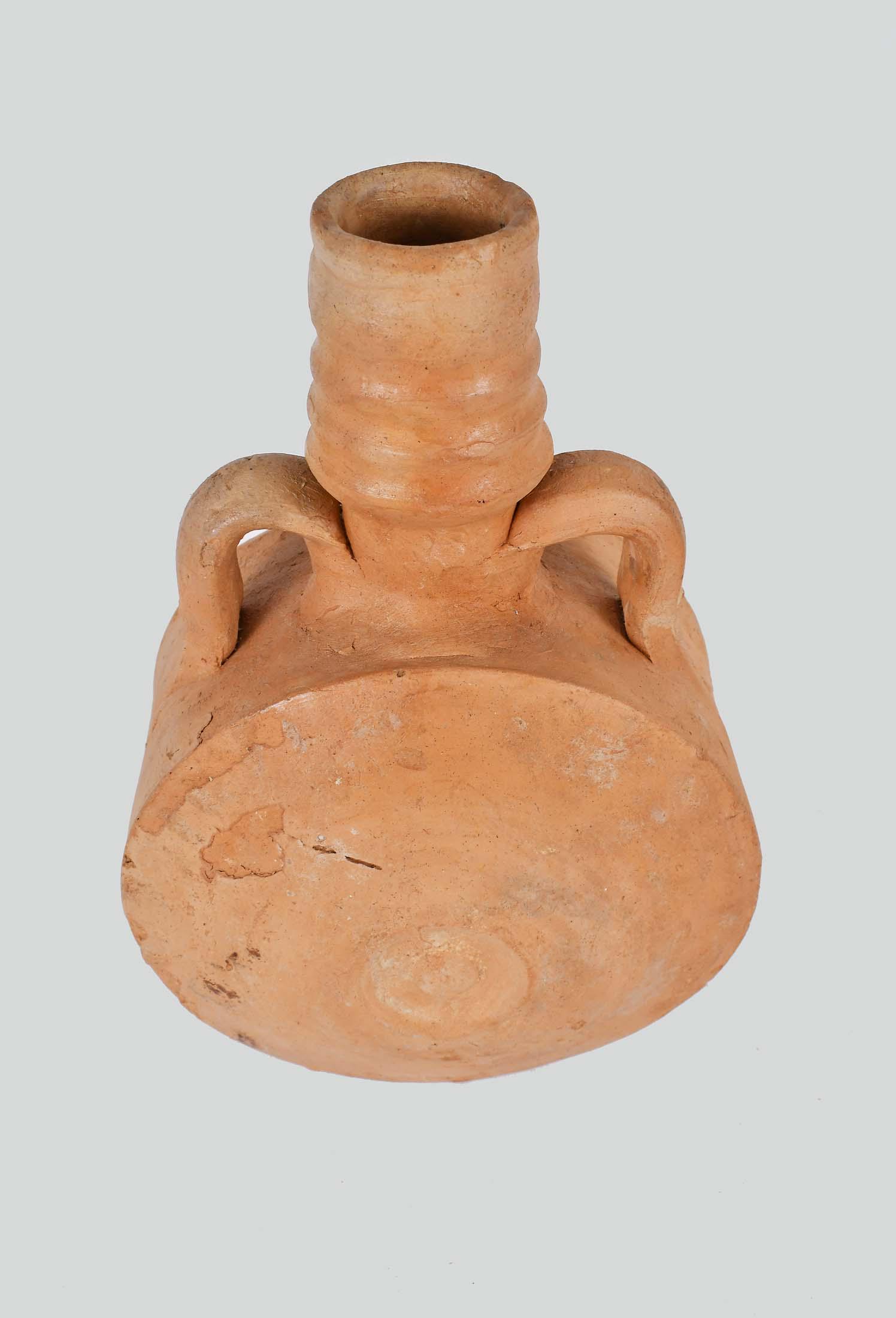 FINE CRUSADE PERIOD RED TERRA COTTA MOON FLASK: Gaza, 1200 A.D. Inscribed Gaza 1200AD M. Dayan. The circular body with a recessed center circular motif to both sides, with double-loop handles set at the shoulder and base of the neck, the elongated
