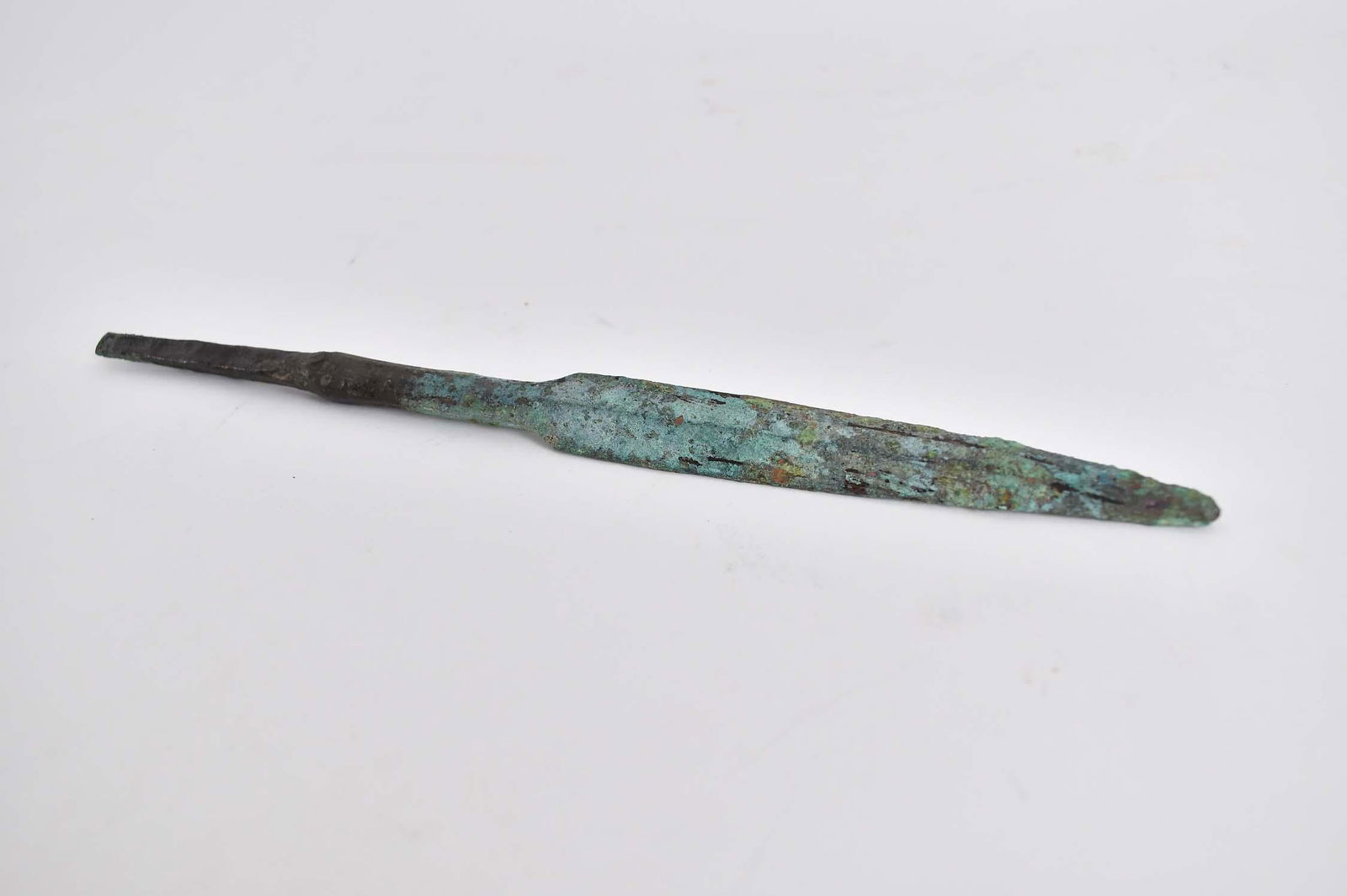 CANAANITE LATE BRONZE AGE SPEAR HEAD: B.C.E. 1800 TO B.C.E. 1500. Double edge tapering to a point, with a long tang, deposits, nice green patina. Length 10 in.Provenance: The Collection of Erwin and Sylvia Harvith, Detroit, MI, acquired i