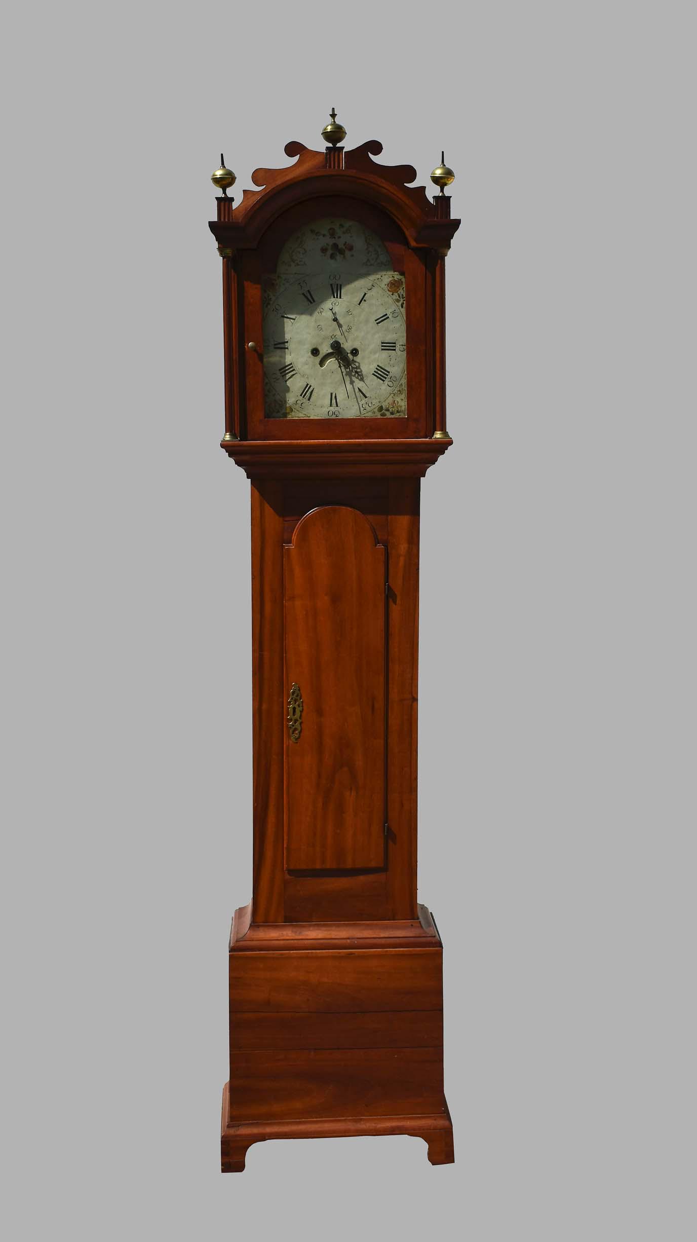 CHIPPENDALE WALNUT TALL CASE CLOCK: American, Late 18th/Early 19th Century. Unsigned. The hood with an overhanging a cornice, above a glazed door, flanked by free-standing columns; the case with an arched door above a rectangular base, 