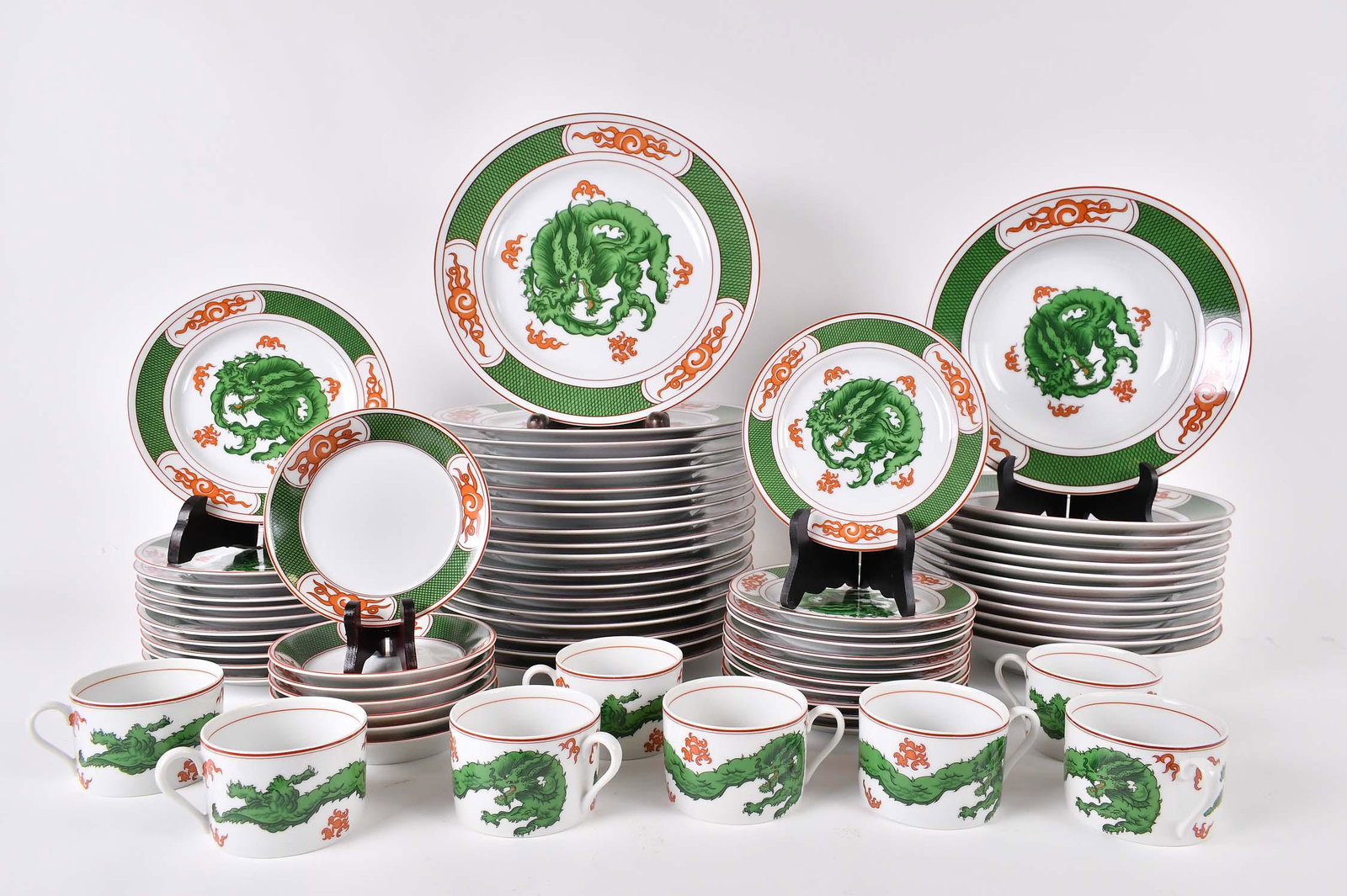 FITZ & FLOYD 61 PIECE DRAGON CREST PART DINNER SERVICE: Modern. The undersides marked. The porcelain service decorated with green dragons and stylized clouds in iron red. Comprising: 19 dinner plates, 12 soup plates, 11 luncheon plates, 11 bread plates, 7 