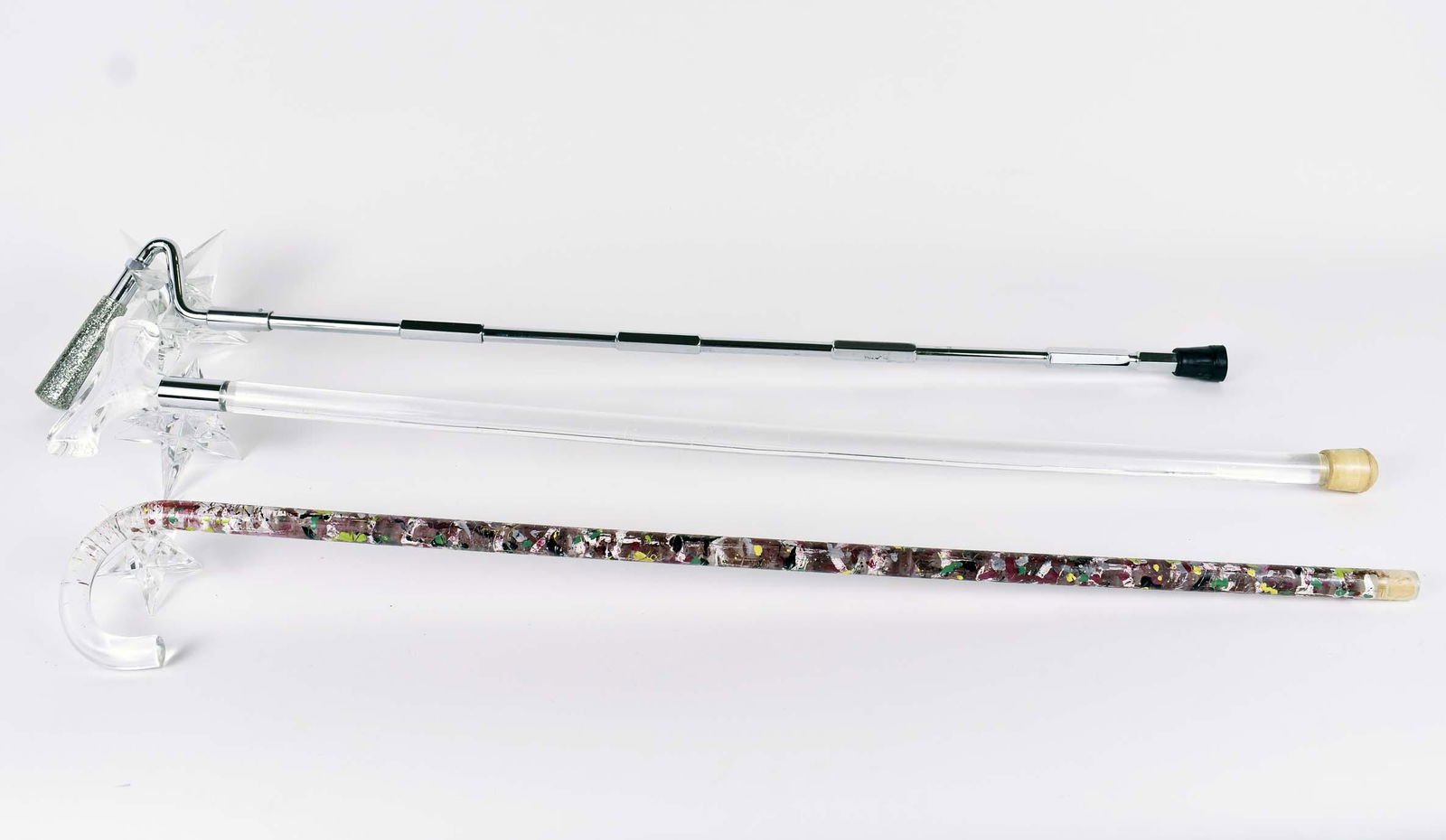 TWO LUCITE CANES AND A STEEL HIKING STAFF: Modern. One Lucite example drip-painted later. Lengths 36 in. to 38 in. (Cond: good)