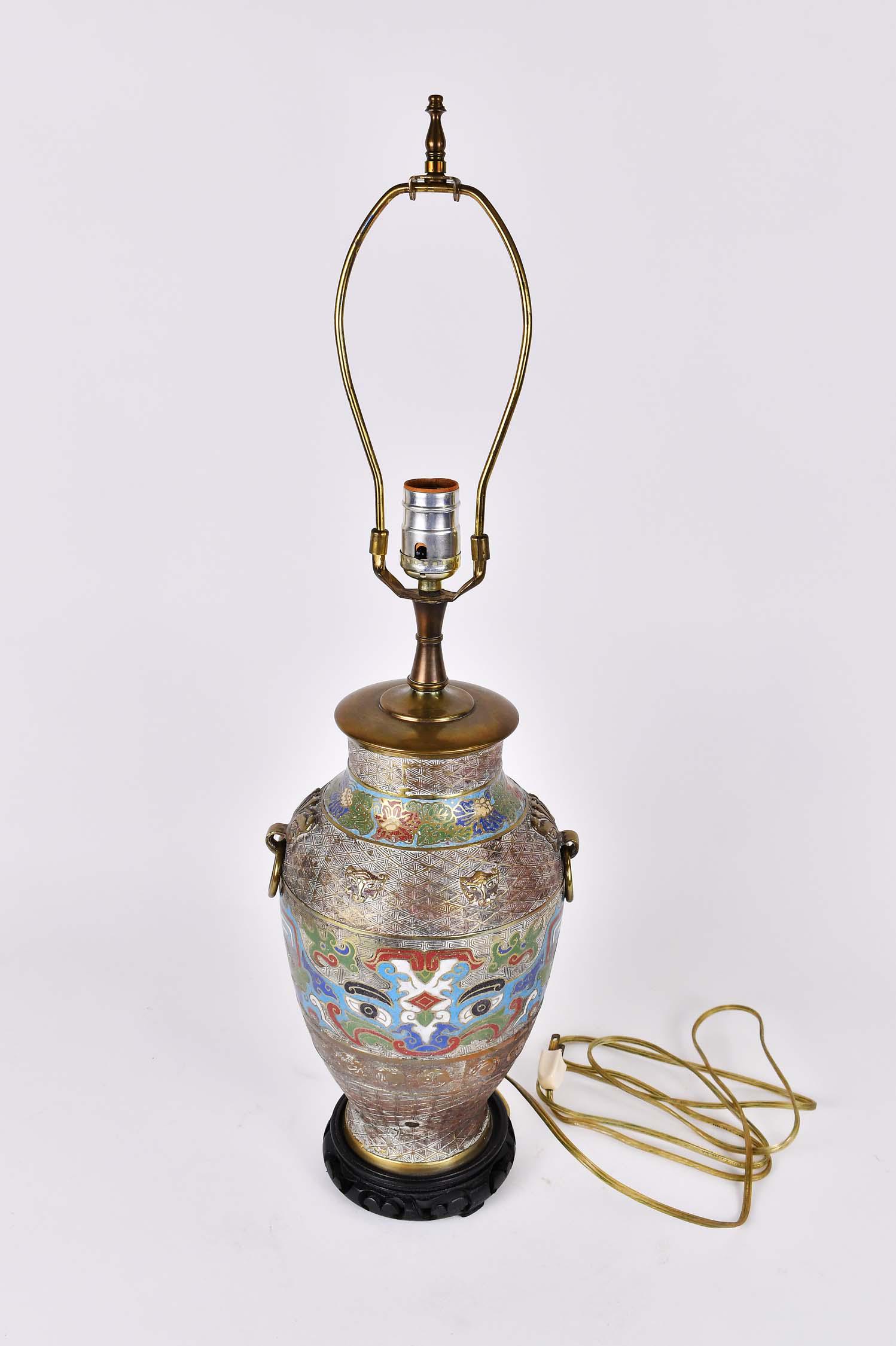 CHINESE CLOISONNE ENAMEL ON BRASS LAMP: 20th Century. The vase form vessel with ring at the side, and with two enamel insets bands, electrified, on a wood base. Height 12.5 in., overall 27 in. (Cond: drilled, otherwise good)