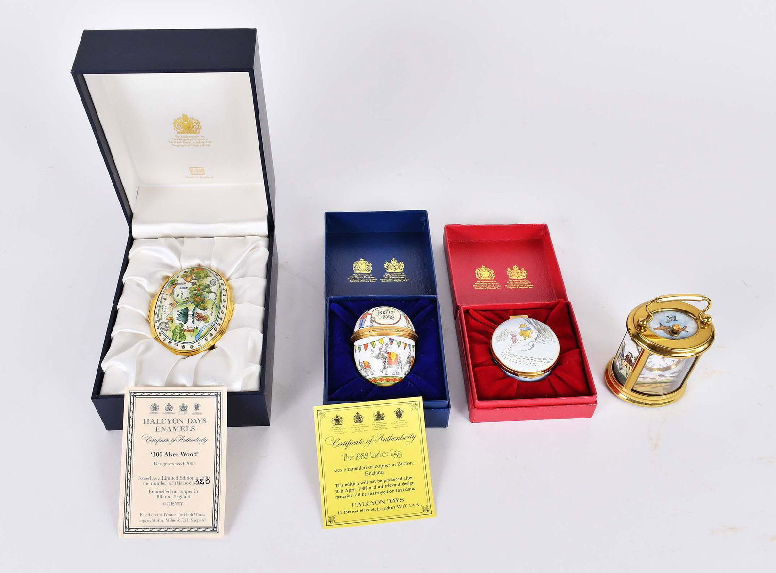 THREE HALYCON ENAMEL TRINKET BOXES & A CLOCK: Modern. The undersides marked. Two of the boxes decorated with references from the Disney movie Winnie The Pooh, the third an Easter Egg dated 1988, decorated with circus scenes, the clock decorated w
