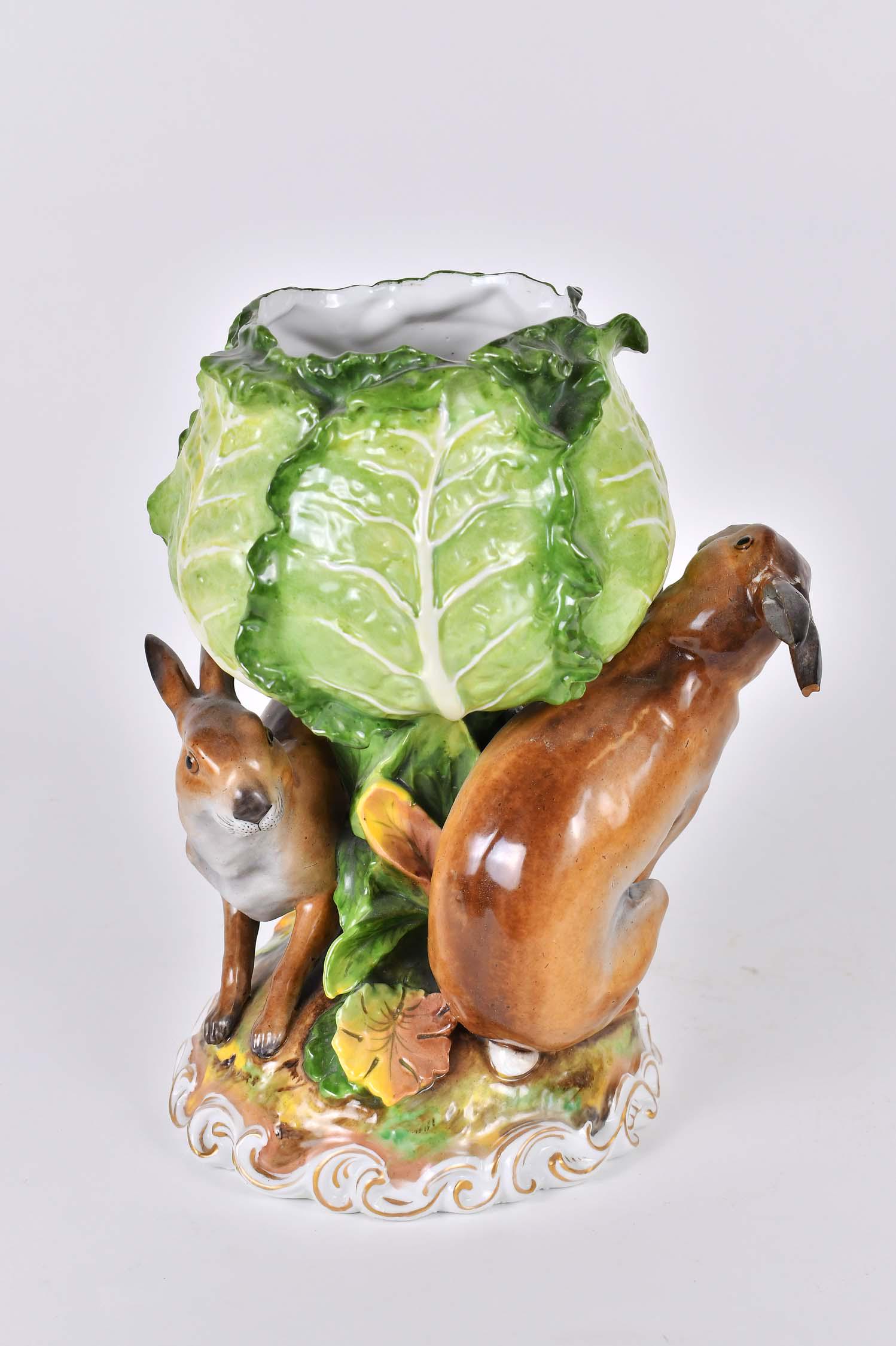 CONTINENTAL FOLIATE AND GAME MODELED PORCELAIN VASE: Circa 1900, probably French, Paris Porcelain. Modeled as a large head of cabbage with two rabbits on a mound, the base with a scrolled border, gilt highlights. Height 11.5 in. Width 8 in. (Cond: good)