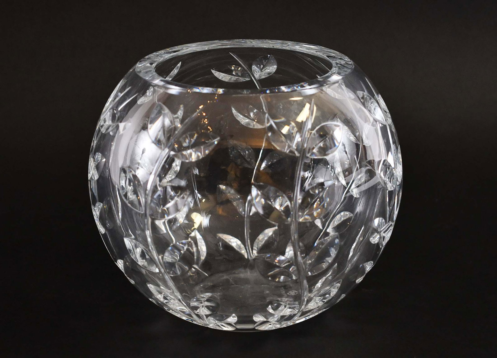 TIFFANY & CO. COLORLESS GLASS SPHERICAL VASE: Modern. The exterior cut with stylized leafy vines. Height 6.25 in. Diameter at rim 5.5 in.