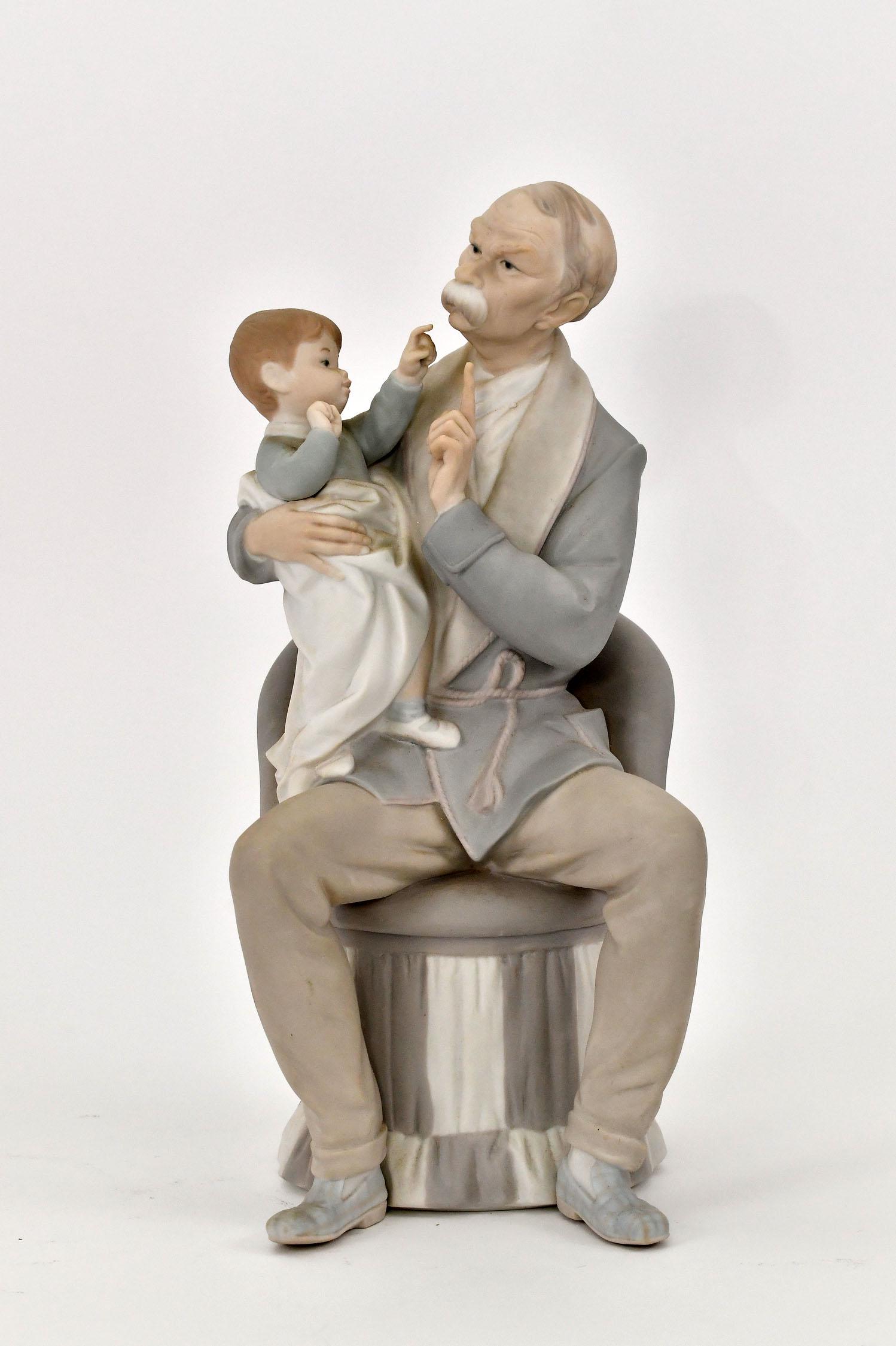 LLADRO PORCELAIN GROUP OF AN ELDERLY MAN WITH BABY: Signed, numbered on the underside. Probably a grandfather with his grandson. Height 12 in. Width 5.25 in. (Cond: good)