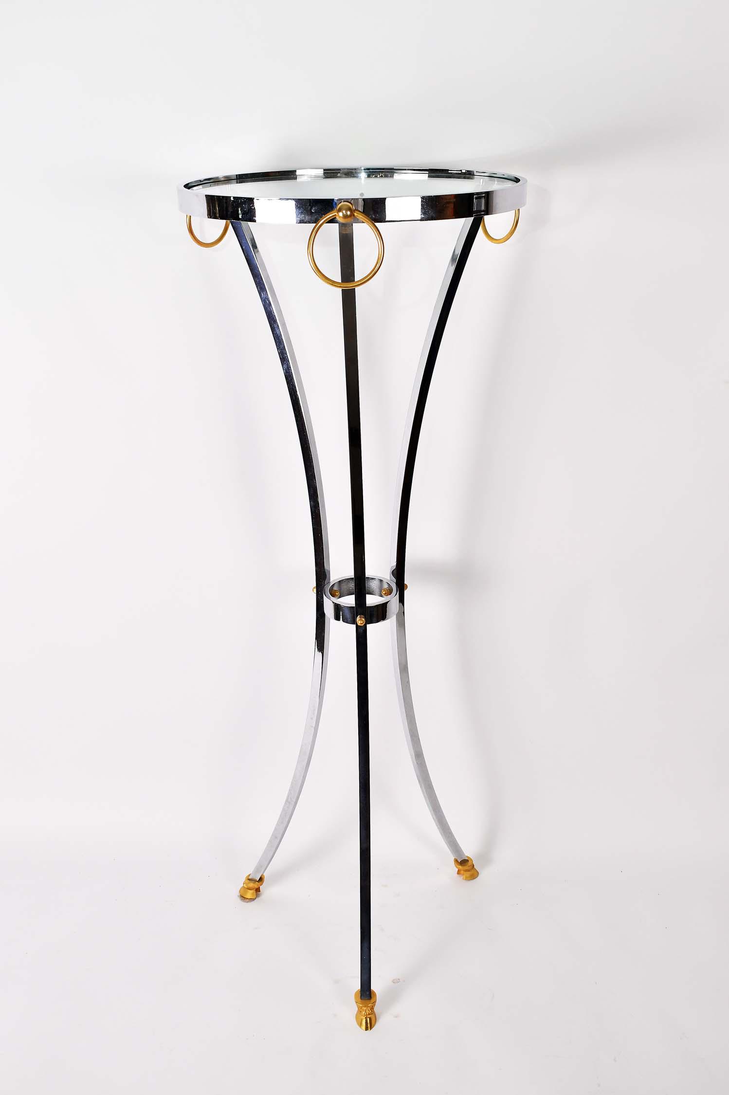 CONTEMPORARY CHROME & GLASS CIRCULAR PEDESTAL TABLE: The colorless glass top raised on a chrome tripod support with brass rings and brass hoofed feet. Height 42 in. Diameter 15.75 in. (Cond: good)