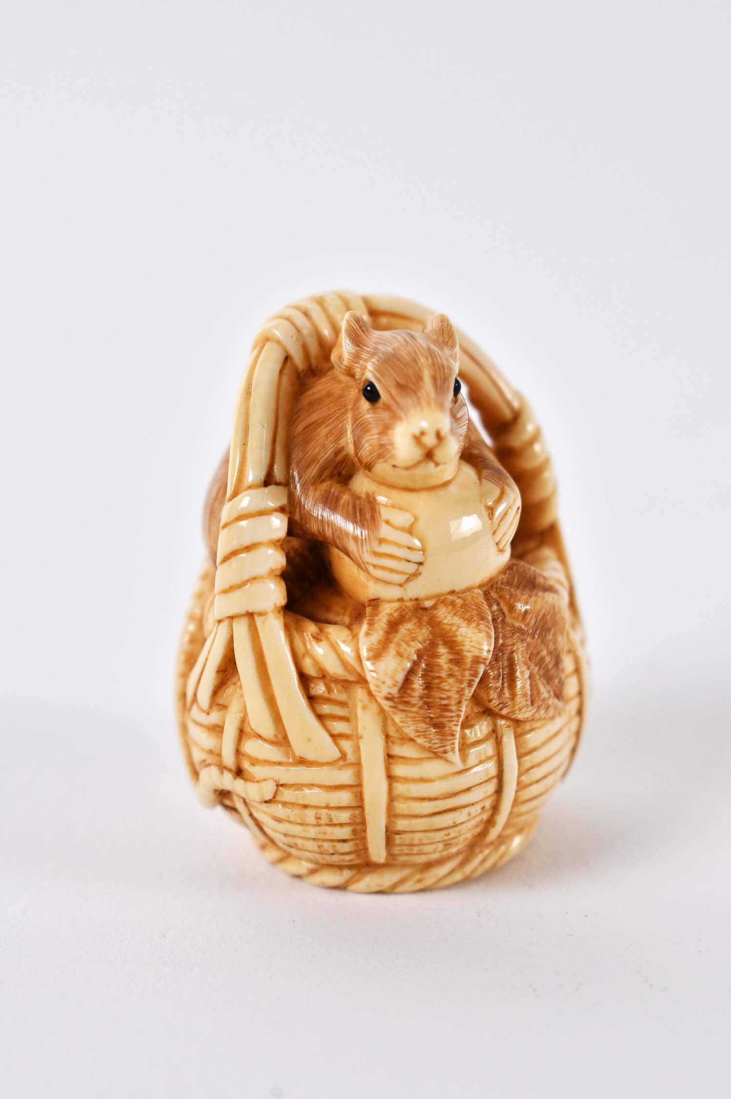 JAPANESE NETSUKE OF A RAT IN A BASKET: Signed with two characters in a box. Height 1.5 in. (Cond: good)