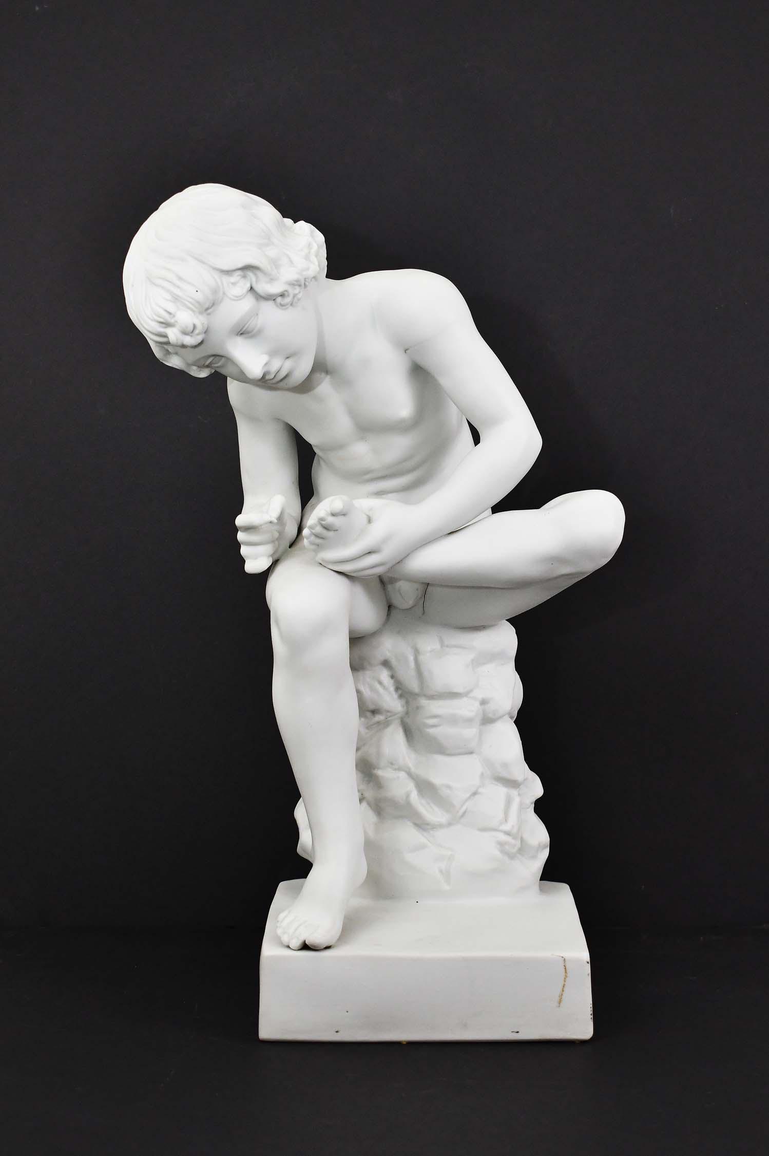 AFTER SPINARIO FEDELINO, A PARIAN WARE NUDE YOUTH: After the Antique. The nude youth seated on a rock pulling a thorn from his foot. Height 14 in. Width 7 in. (Cond: good)