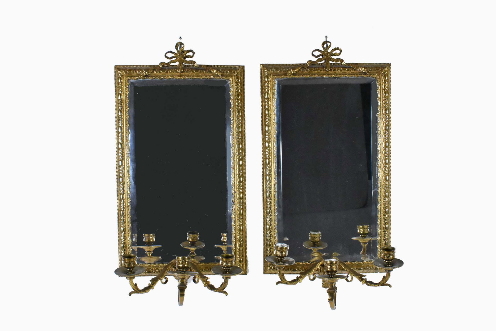 PAIR OF GILT BRONZE THREE-LIGHT MIRRORED SCONCES: The rectangular mirror plates within a bronze border surmounted by a bow-tie, the lower edge supporting three candle arms. Height 21 in. Width 12 in. Depth 8 in. (Cond: good)