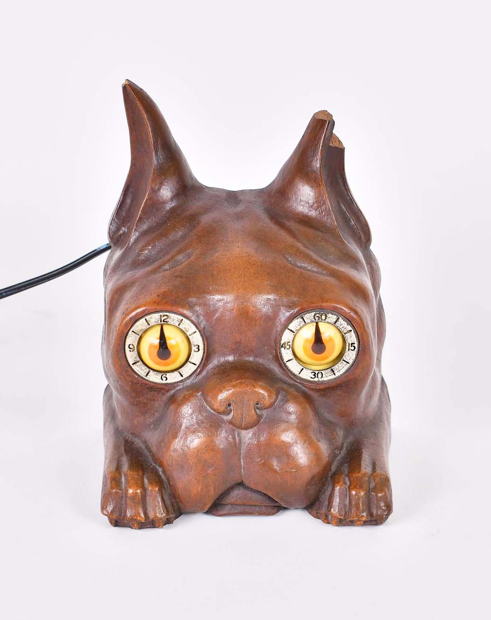 THE DUKE CLOCK VINTAGE SESSIONS ELECTRIC CLOCK: Circa 1940. The reverse with applied manufacturers metal tag and an Abercrombie & Fitch retail label. The carved walnut dogâ€™s head with inset eyes that rotate around two dials, one hourly, the 