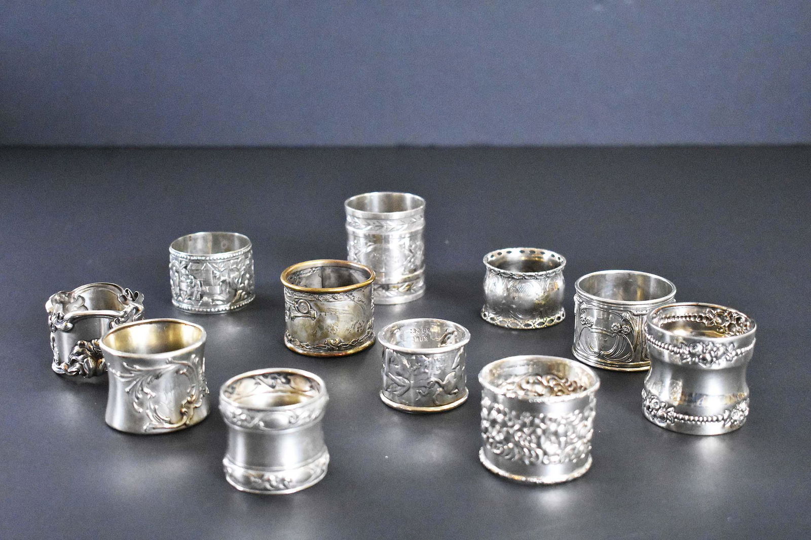 ELEVEN ENGLISH AND AMERICAN SILVER NAPKINS RINGS: Late 19th/First Half 20th Century. Many marked. Including examples with Birmingham, Duhme & Co., Gorham hallmarks, most with either chased or repousse Neo-classical and Rococo motifs, one with fairy t