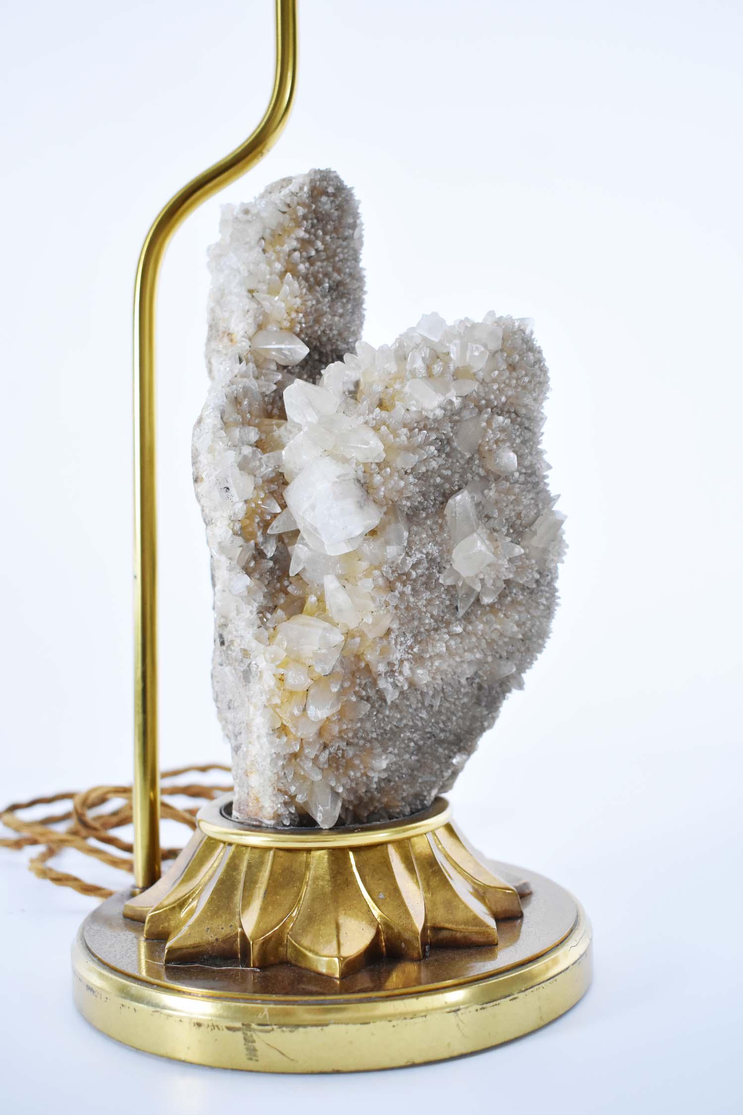 ANTIQUE QUARTZ MINERAL SPECIMAN MOUNTED AS A LAMP: The asymmetrical mineral resembling two towers composed of both small and large projecting quartz crystals, with some gray coloration, set into a gilt bronze base with a pointed lappet collar and circ