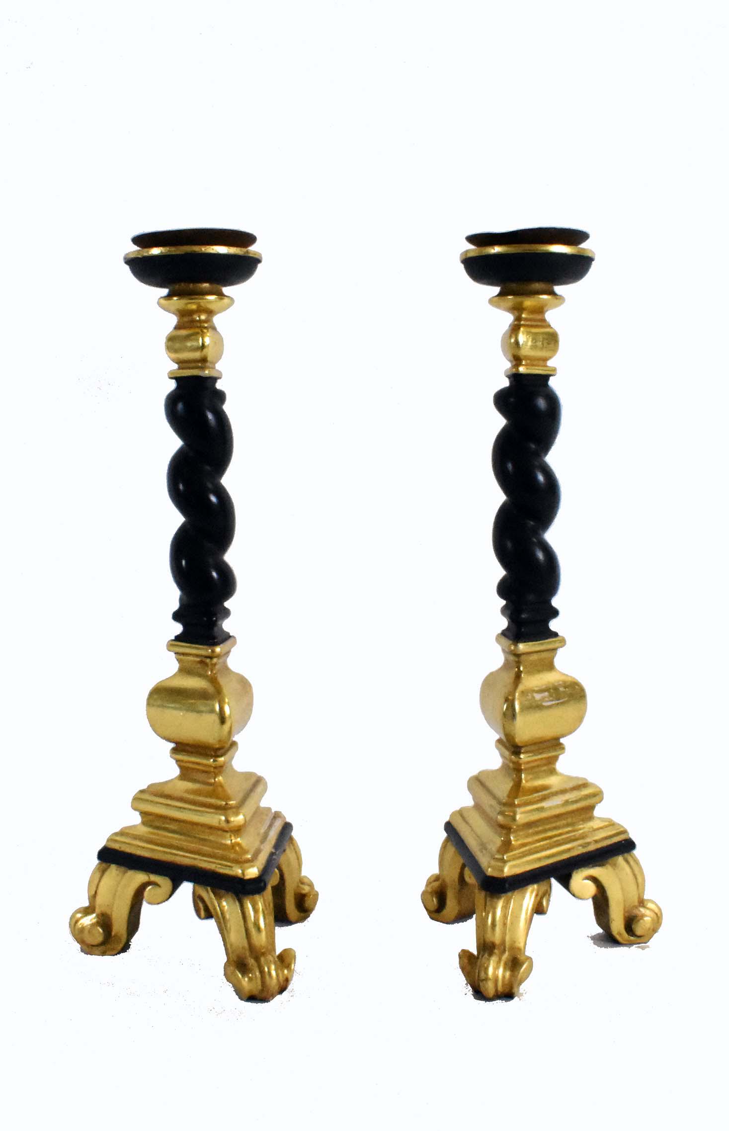 PAIR OF EBONIZED & GILTWOOD CANDLESTICKS: In Baroque style. With spiral columnar standards, dish-form nozzles and a shaped base with scrolled feet. Height 19 in.