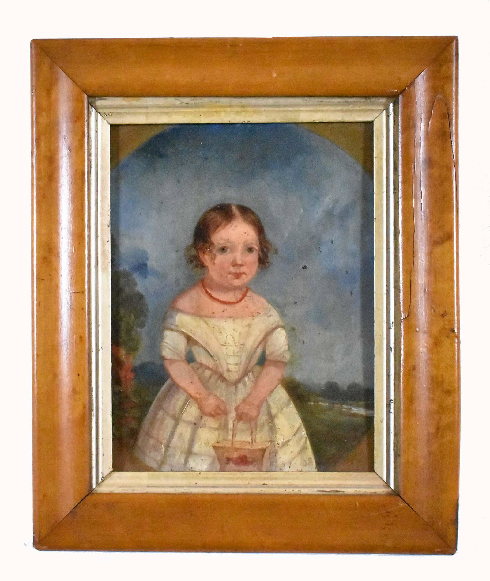 AMERICAN SCHOOL (EARLY 19TH CENTURY) PAINTING: Young Child Holding a Basket in a Landscape. Unsigned. Oil on Board. Measuring 8.50 x 6.50 inches. In an antique maple frame 12 x 10 inches.