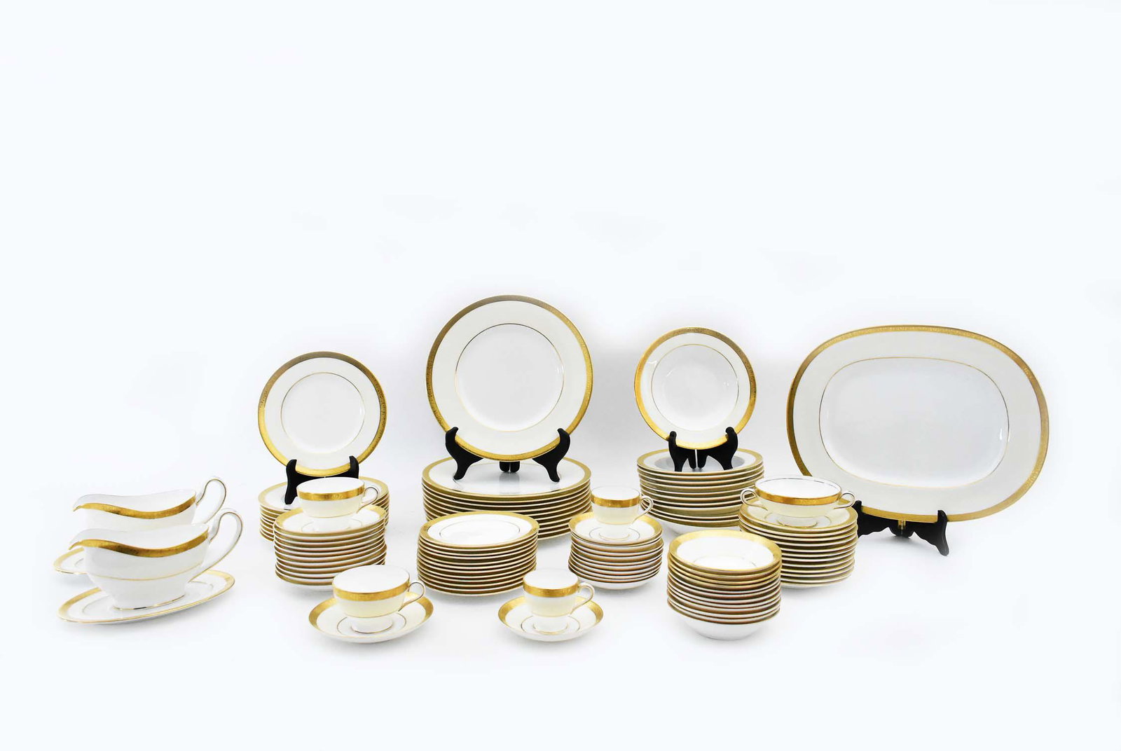 MINTON GILT DECORATED PORCELAIN DINNER SERVICE: 2nd/3rd Quarter 20th Century. The underside of each marked with a Minton wreath in black, also impressed and with red production/painter marks. Each of the 172 elements with raised gilt borders. Compr