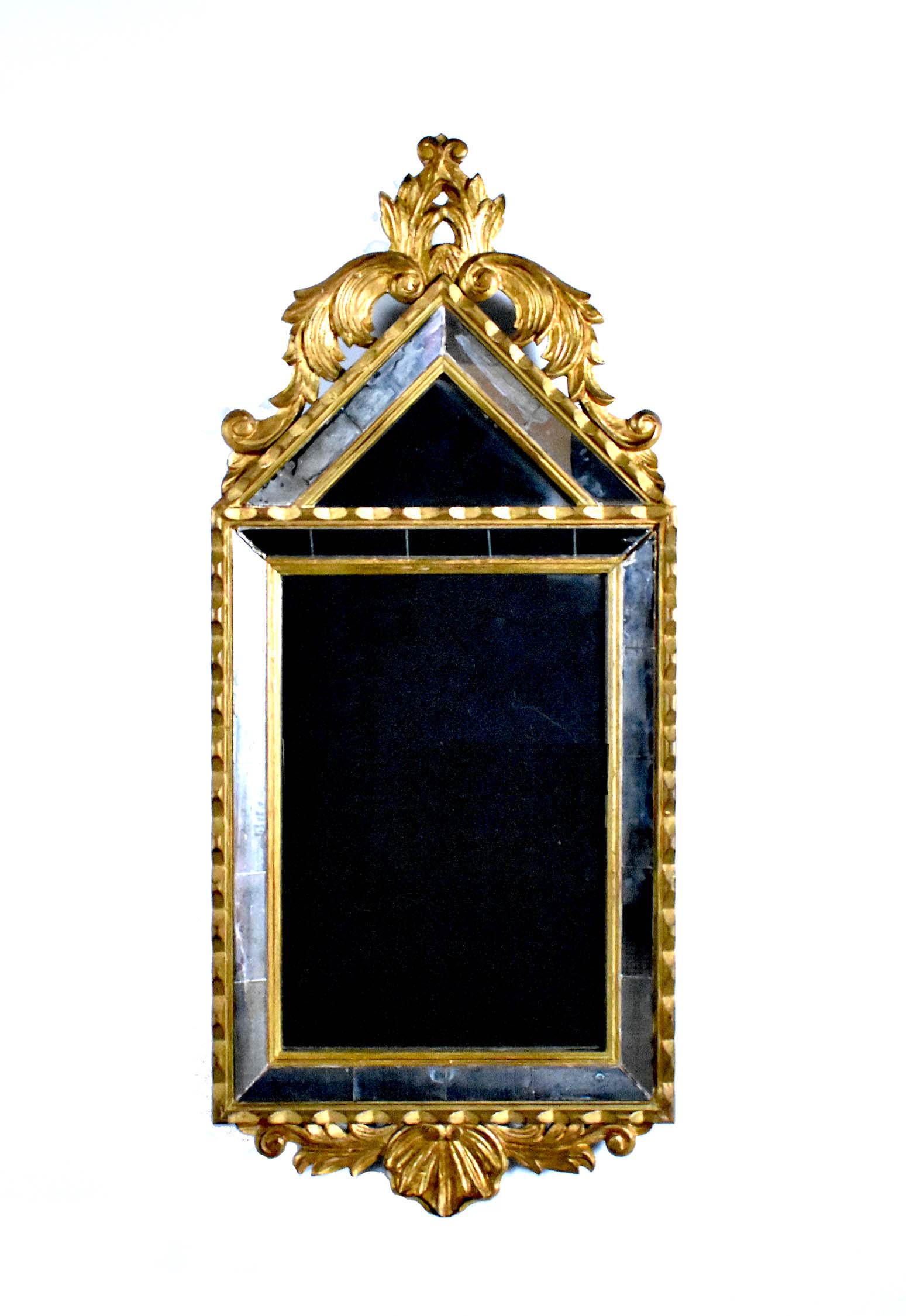 ITALIAN BAROQUE STYLE GILTWOOD MIRROR: The mirror-framed-mirror with a pointed arched crest carved with pierced leafage, the pendant with a shell. Height 31 in. Width 13.5 in.