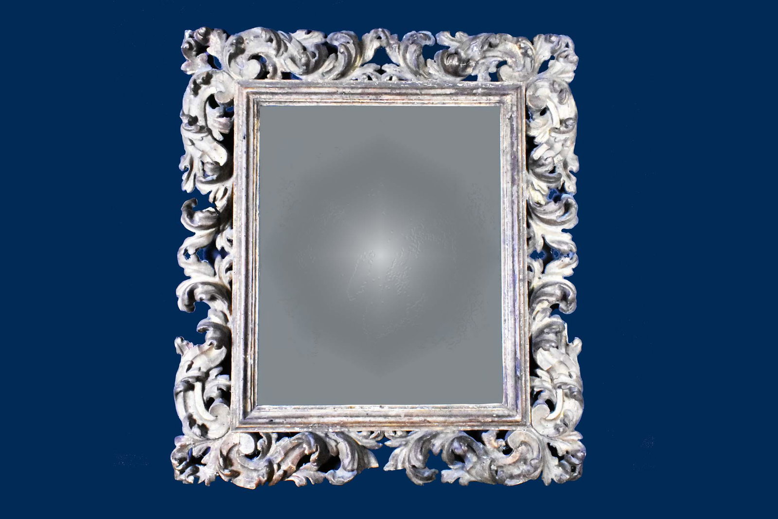 ITALIAN ROCOCO GILTWOOD MIRROR: 18th Century. The rectangular mirror plate within a pierced surround carved with scrolls and leafage. Height 33 in. Width 29 in. (Cond: some repaired scrolls, minor losses) Provenance: Property of The
