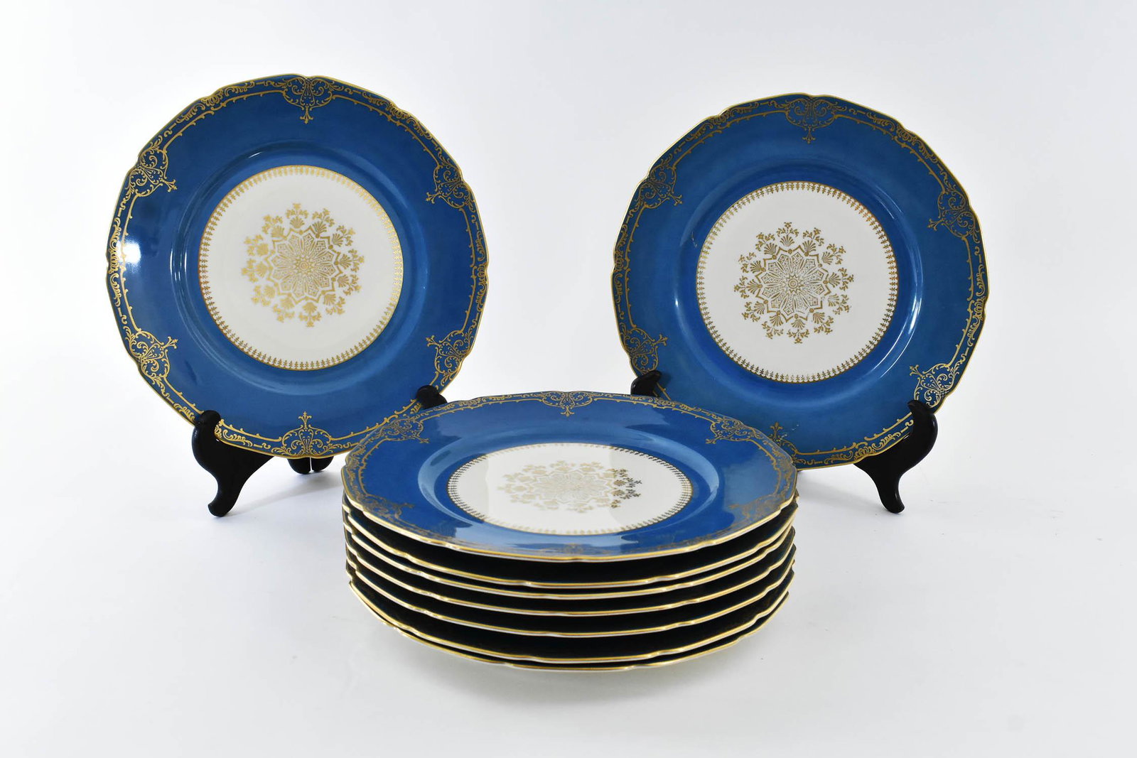 NINE GERMAN PARCEL GILT PORCELAIN SERVICE PLATES: Circa 1920. Marked Continental Ivory, Bavaria the recessed center with a gilt rosette and scrolls, the wide aqua rim with gilt scrolls. Diameter 10.5 in. The Haggstrom Trust, Jupiter, FL