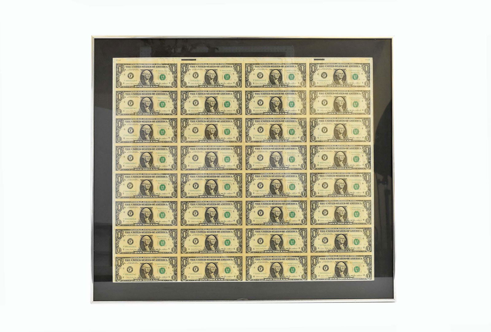 SHEET OF THIRTY-TWO UNCUT ONE DOLLAR BILLS: Framed. 1965, sheet number 177145. Sheet measuring 20.5 by 23.75 in., overall, 25 by 29 in. (Cond: glass broken upper right)