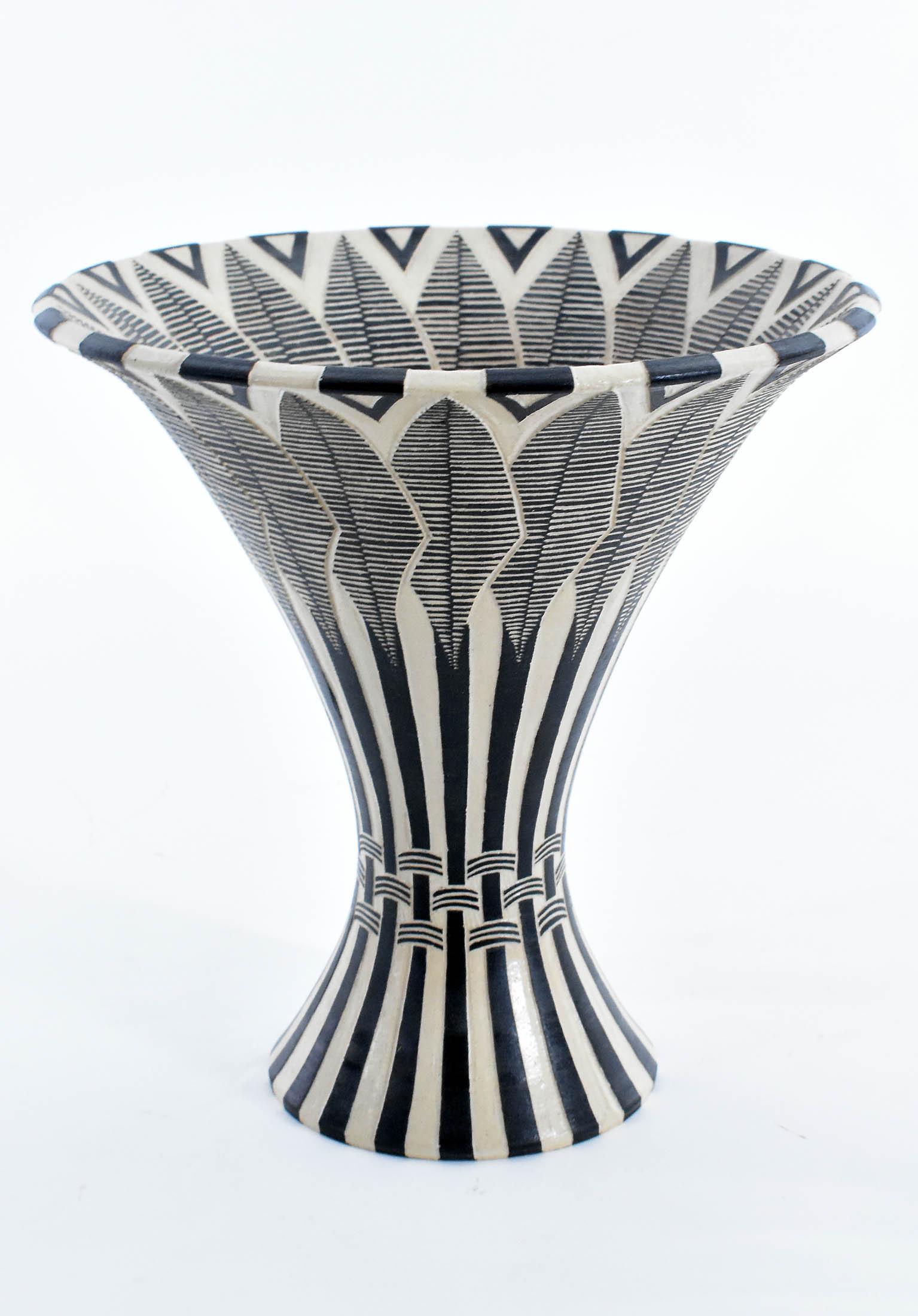 ERIK BRIGHT EARTHENWARE VASE: The underside signed, dated Jan. 31, 98, with inscription. The flared mocha colored vessel overlaid in a darker brown, and carved with stylized palm fronds. Height 10 in. Diameter 10 in.