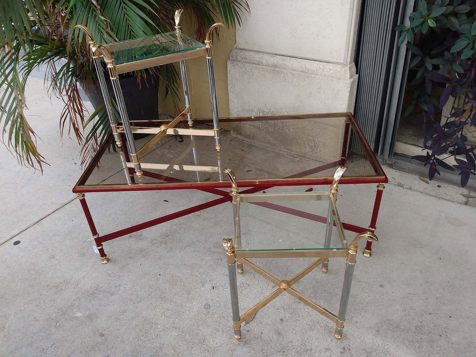 GLASS AND BRASS LOW TABLE & PAIR OF SIDE TABLES: Contemporary. The rectangular table with patinated brass frame, with an X-form stretcher, the square tables with a glass top and mid shelf. (3 pcs) Height of low table 17.5 in. Width 249 in. Depth 24 