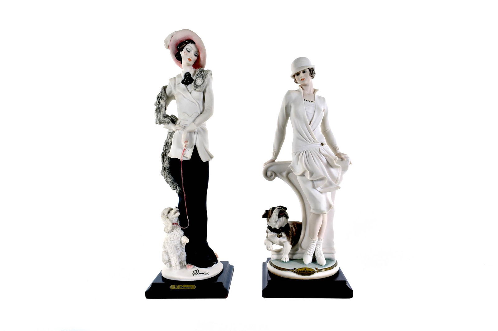 TWO GIUSEPPE ARMANI WOMEN WITH THEIR DOGS: Made For Capodimonte, marked. The first, in a long skirt with smart jacket and a hat, her poodle by her side; the second, in a white dress with bowler hat, her bulldog by her side. Heights 13.5 in., 1