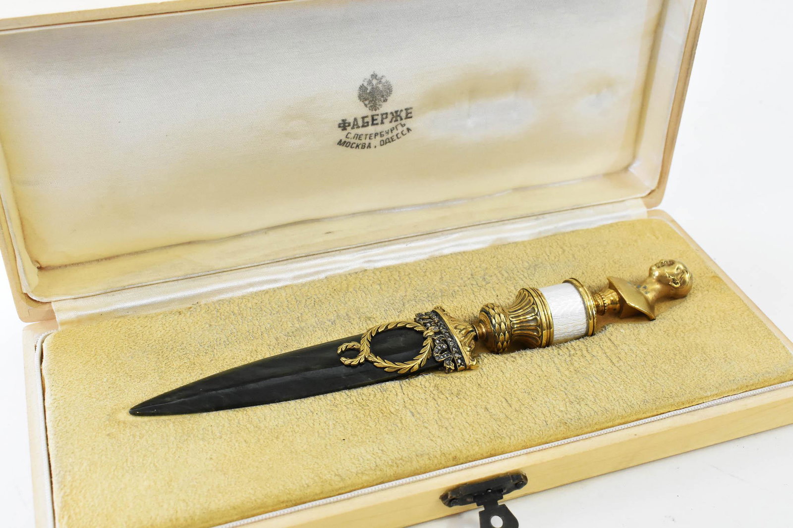 RUSSIAN SILVER GILT, ENAMEL & NEPHRITE PAPER CUTTER: Marked au, 88, and impressed Cyrillic on the bust. The finely silver gilt handle cast with a imperial bust, above a white enamel mid-section, surmounting an urn, the spinach Jade blade applied with a 