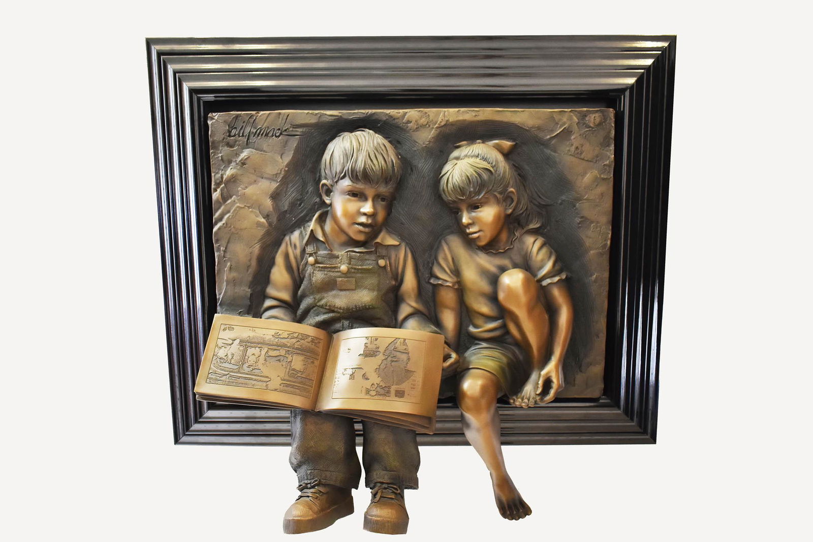 BILL MACK (American. 1929-1920) BAS-RELIEF: Patinated composition panel of a boy and girl reading. Signed u/l. Height 31 in. Width 30 in., overall, in an ebonized frame, 38 by 34 in.