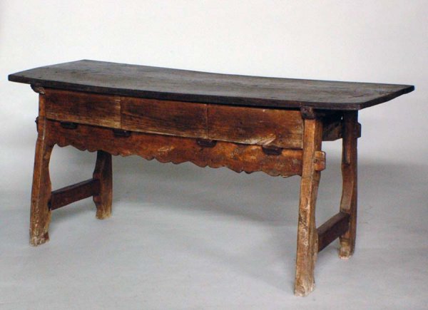 PROVINCIAL OAK HARVEST TABLE: PROVINCIAL OAK HARVEST TABLE French. Early 18th Century. The rectangular top above three frieze drawers and a scalloped apron, raised on trestle supports. Height 31 3/4". Width 68 3/8". Depth 23 1/2".