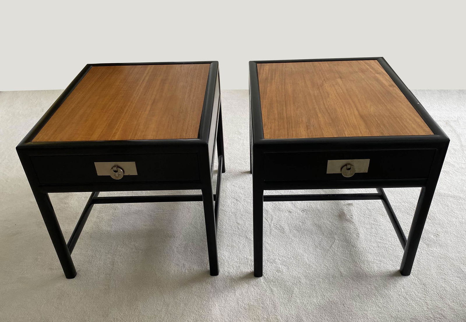 PAIR OF MICHAEL TAYLOR SATINWOOD INSET EBONIZED SIDE: Contemporary. With Baker plate in a drawer. The rectangular top with a satinwood inset panel, the frieze with a drawer, fitted with a brass plate and drawer pull, on straight legs joined by side stret