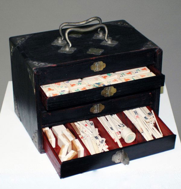 ORIENTAL MAH-JONG SET IN CASE: ORIENTAL MAH-JONG SET IN CASE The mother of pearl inlaid case with brass mounts and handle containing five drawers with playing tiles. Height of case 6 1/2". Width 9 1/2". Depth 6 1/2". (100/150)