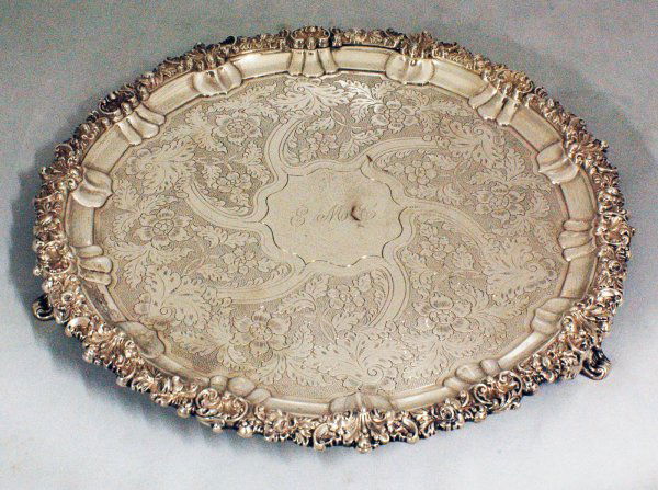 GEORGE IV STERLING SILVER SALVER: GEORGE IV STERLING SILVER SALVER English. Sheffield. 1824. Maker: Young & Co. The circular tray on foliate supports, the center engraved by initials E.M.C., surrounded by leaves and flower heads and e