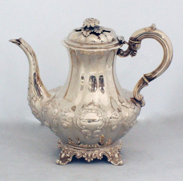 VICTORIAN STERLING SILVER TEA AND COFFEE POT: VICTORIAN STERLING SILVER TEA AND COFFEE POT English. London. 1841. Maker: F.D. Each with double scroll handle and floral chased spout, raised on scroll supports. Height of coffee pot 8 3/4". (49 oz)