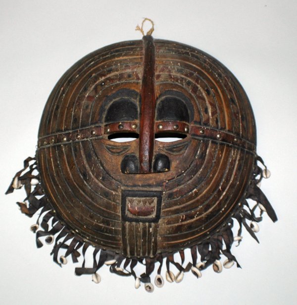 AFRICAN BALUBA "KIFWEBE" TRIBAL MASK: AFRICAN BALUBA "KIFWEBE" TRIBAL MASK Democratic Republic of Congo. Wood, cowrie shells and leather. Height 16". Width 16". (Cond: nicks and chips, normal wear) (250/350)