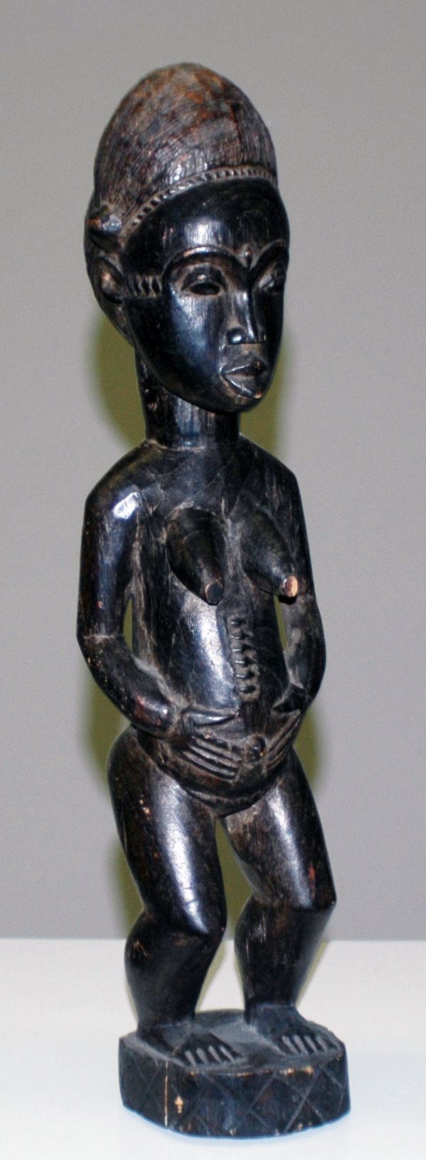 AFRICAN FEMALE BAULE ANCESTOR FIGURE: AFRICAN FEMALE BAULE ANCESTOR FIGURE Ivory Coast. Wood. Height 19". (Cond: normal wear with nick to one breast) (250/350)