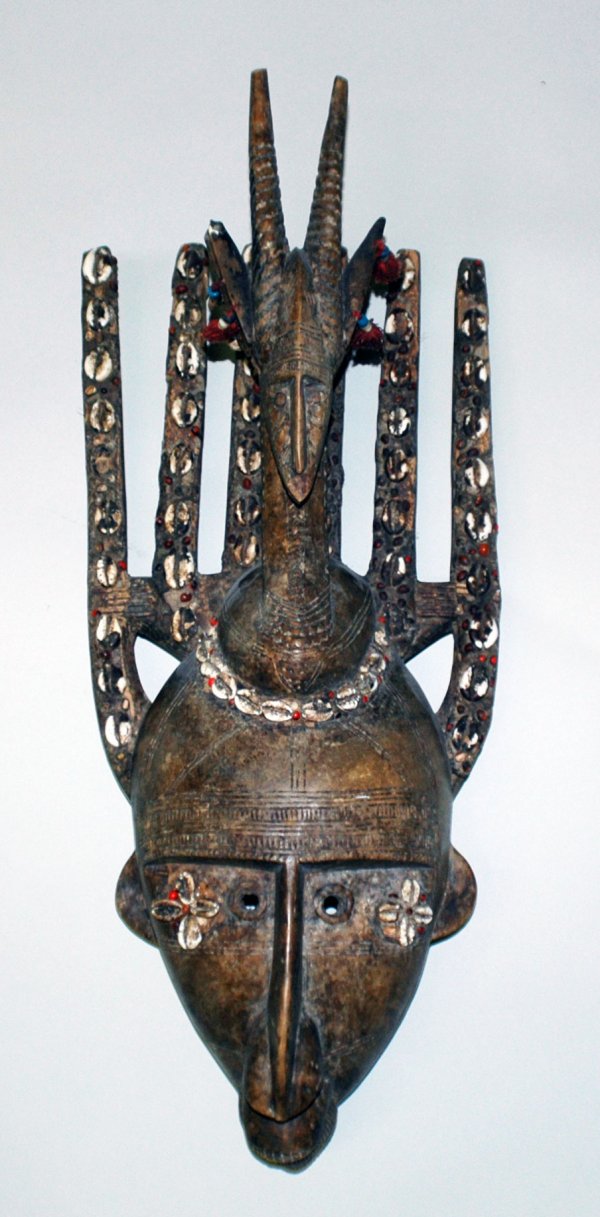 AFRICAN N'TOMO SOCIETY, BAMBARA TRIBAL MASK: AFRICAN N'TOMO SOCIETY, BAMBARA TRIBAL MASK Republic of Mali. Wood with cowrie shells, beads, red berries and textile. Measuring 24 1/2" high by 10" wide. (Cond: some nicks and chips, overall good) (2