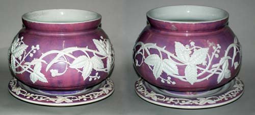 PAIR OF SARREGUEMINES FAIENCE JARDINIERES & STANDS: PAIR OF SARREGUEMINES FAIENCE JARDINIERES & STANDS French. Circa 1900. Printed factory mark and impressed 345. Each pink globular vessel molded with blossoming vines in shallow relief. Diameter 10 1/2