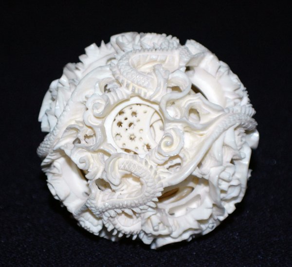 CARVED IVORY CONCENTRIC BALL: CARVED IVORY CONCENTRIC BALL Chinese. The outer ball with dragons, containing nine pierced inner balls. Diameter 2 1/2". (150/200)