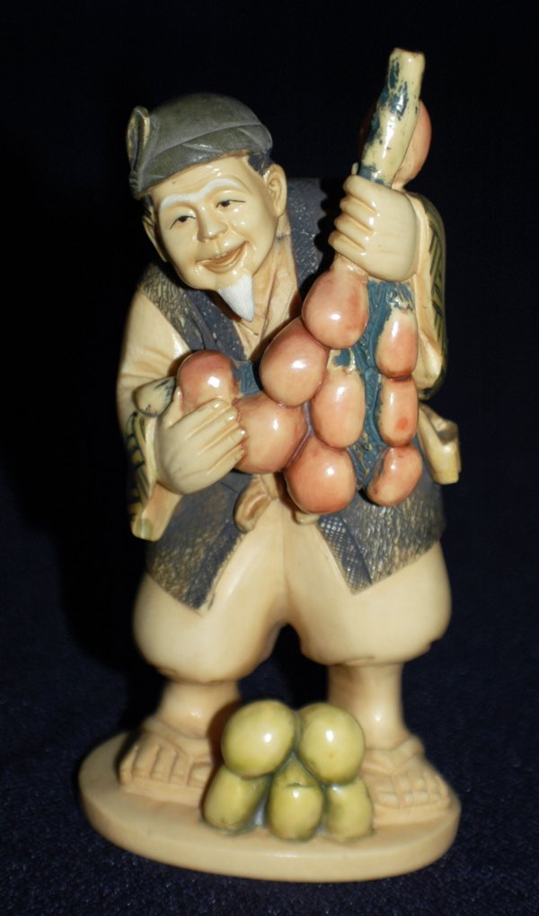 CARVED IVORY FIGURE OF A FRUIT SELLER: CARVED IVORY FIGURE OF A FRUIT SELLER Japanese. Signed. Wearing a cap, short jacket and sandals. Height 5". (300/400)