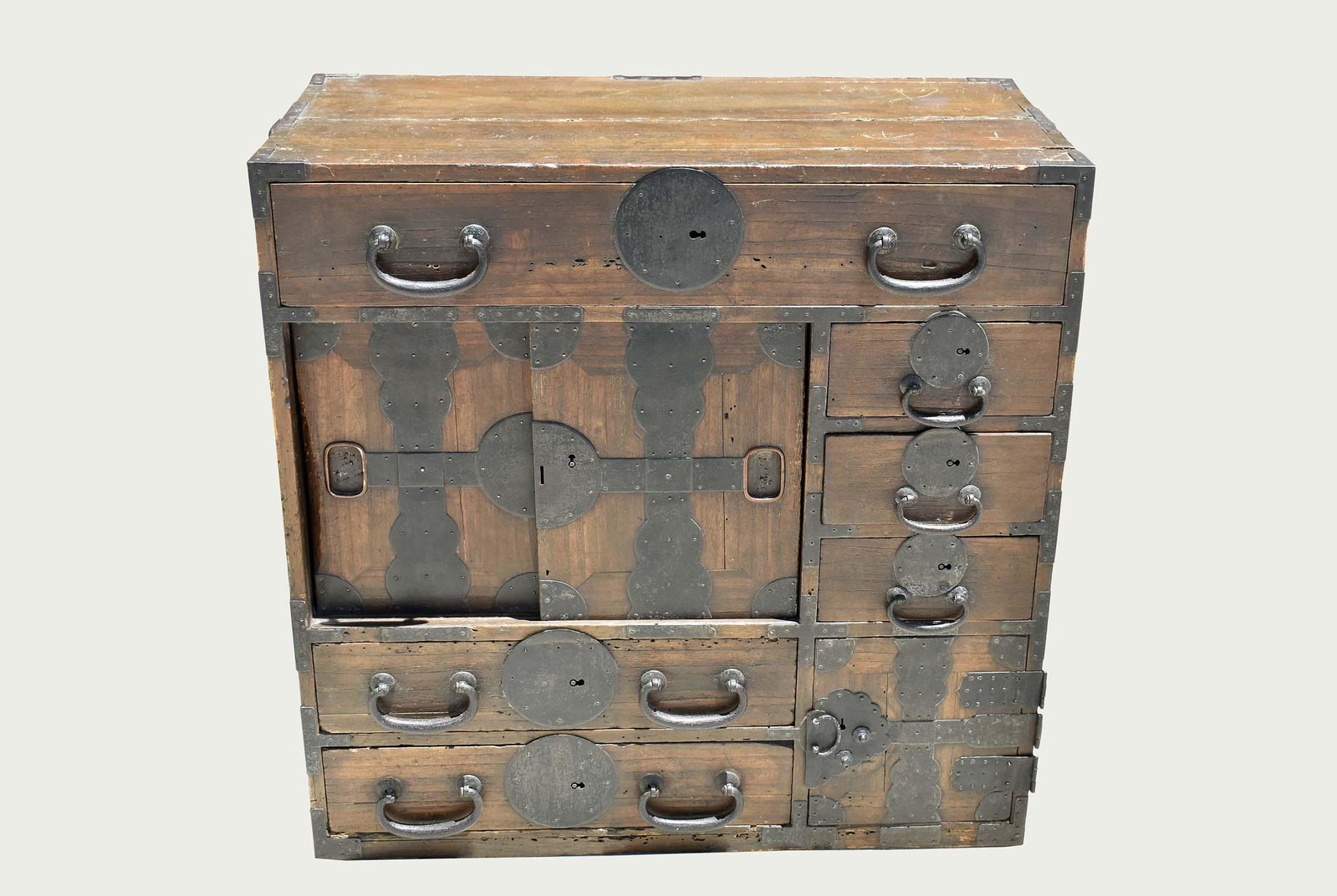 JAPANESE METAL-MOUNTED SOFT WOOD TANSU: Late 19th Century. The rectangular case fitted with drawers and sliding doors, with side carrying handles, the drawers mounted with heavy bail handles. Height 31in. Width 31 in. Depth 15.5 in. (Cond: 